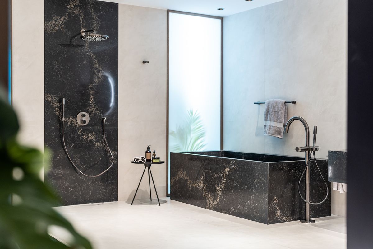A bathroom setting with shower area and bathtub in matching dark finish