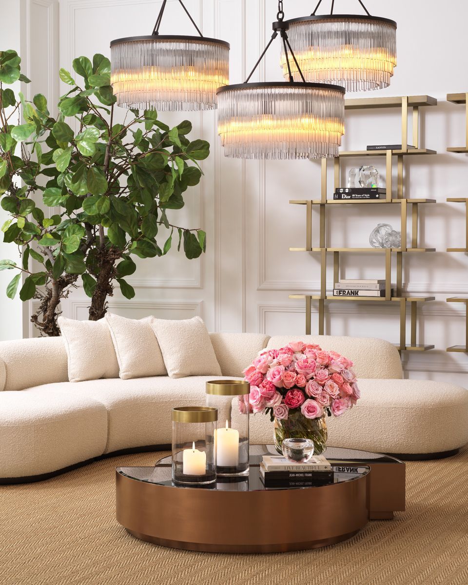 A corner decorated with curvy sofa and three circular chandeliers