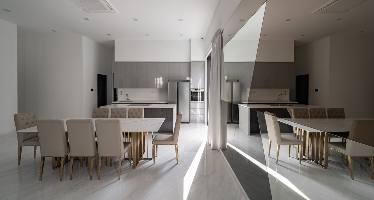The interplay of various geometric forms and tinted surfaces adds visual interest to the open-plan dining room