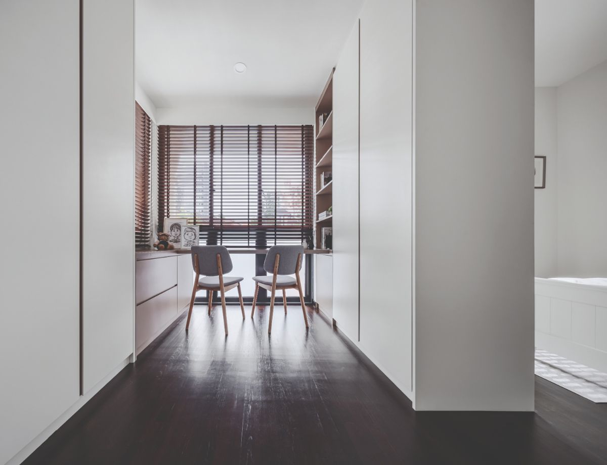 Built-in cabinetry separates the beds from the wardrobe area, which also features a desk that looks out to the neighbourhood
