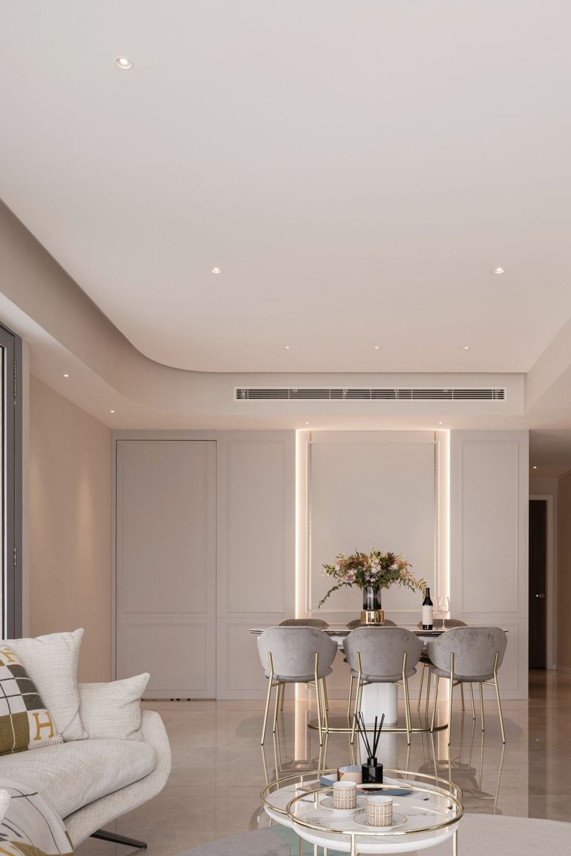 The dining chairs sport rounded forms that contrast with the rectilinear beading on the walls