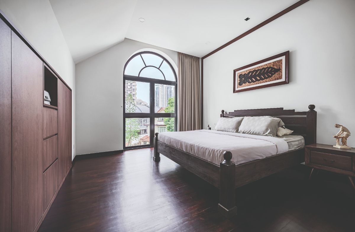 The dark-wood bed frame loosely references the neoclassical architectural elements of the semi-detached house