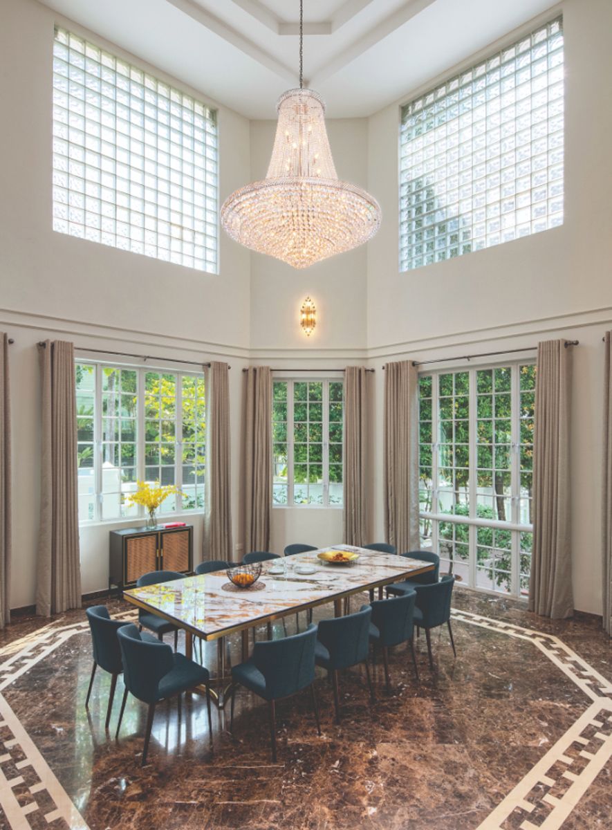 A chandelier above the spacious dining area emphasises the lofty height of the space