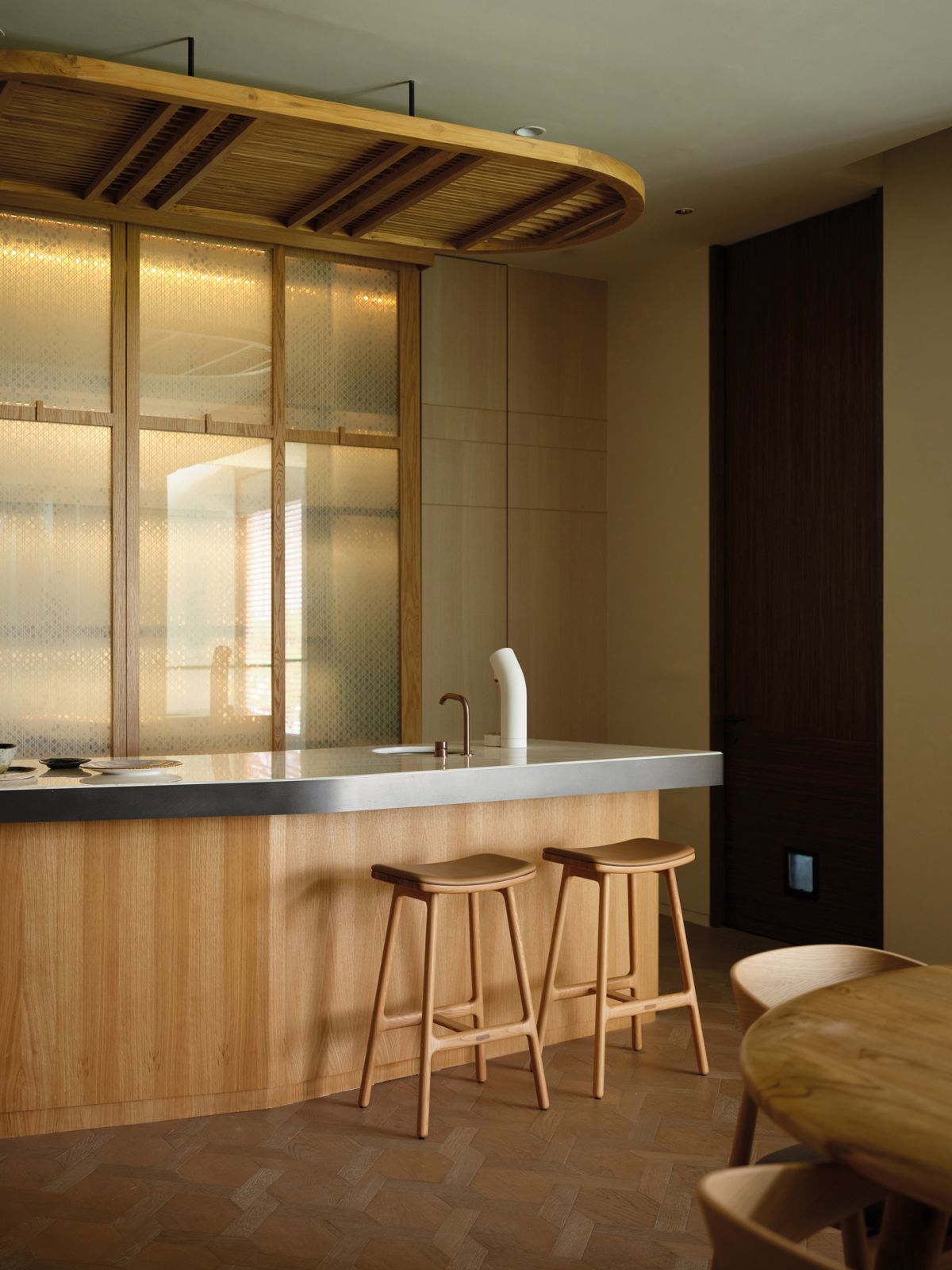 The glass-laminated patterned banana paper sliding doors lend subtle tactility to the bar area