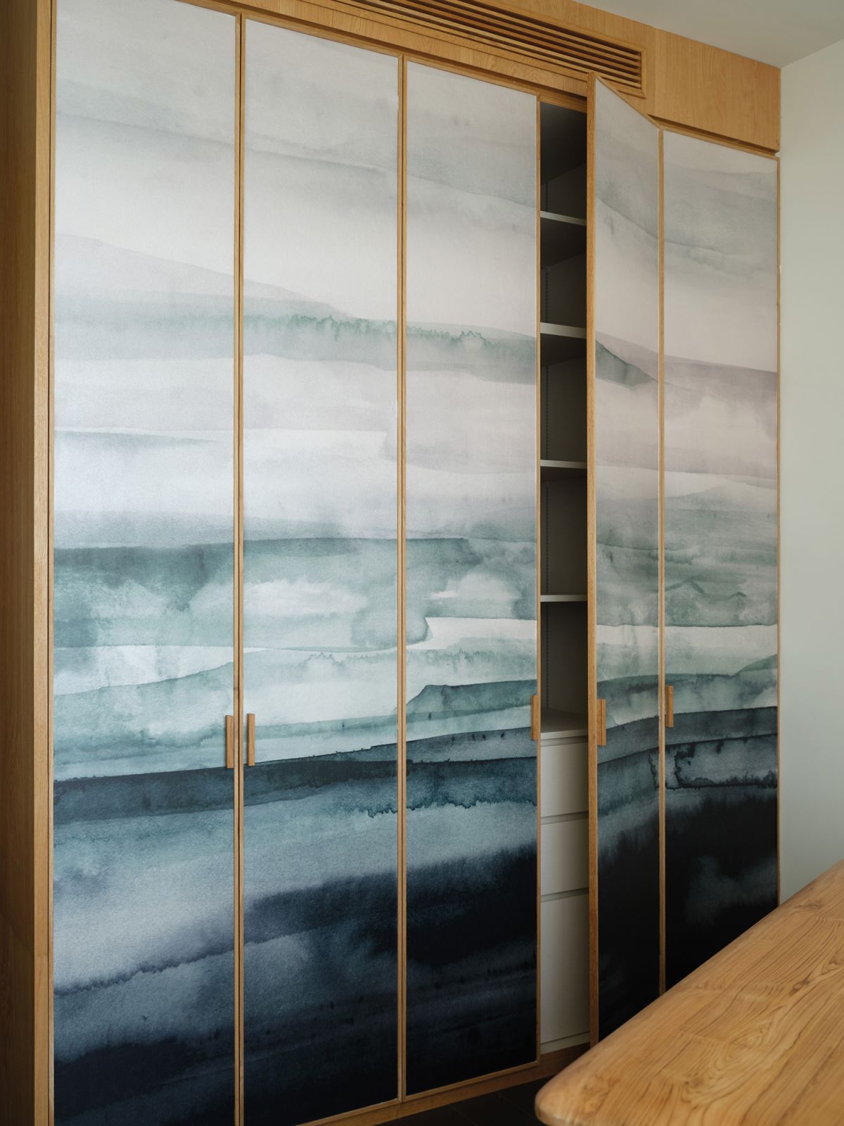 This storage space is hidden by sliding doors finished with ink-effect wallpaper