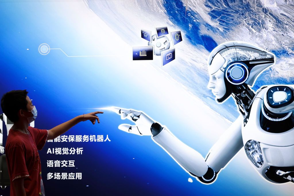 BEIJING, CHINA - AUGUST 18: A boy points to the AI robot Poster during the 2022 World Robot Conference at Beijing Etrong International Exhibition on August 18, 2022 in Beijing, China. The 2022 World Robot Conference kicked off on Thursday in Beijing. (Photo by Lintao Zhang/Getty Images)