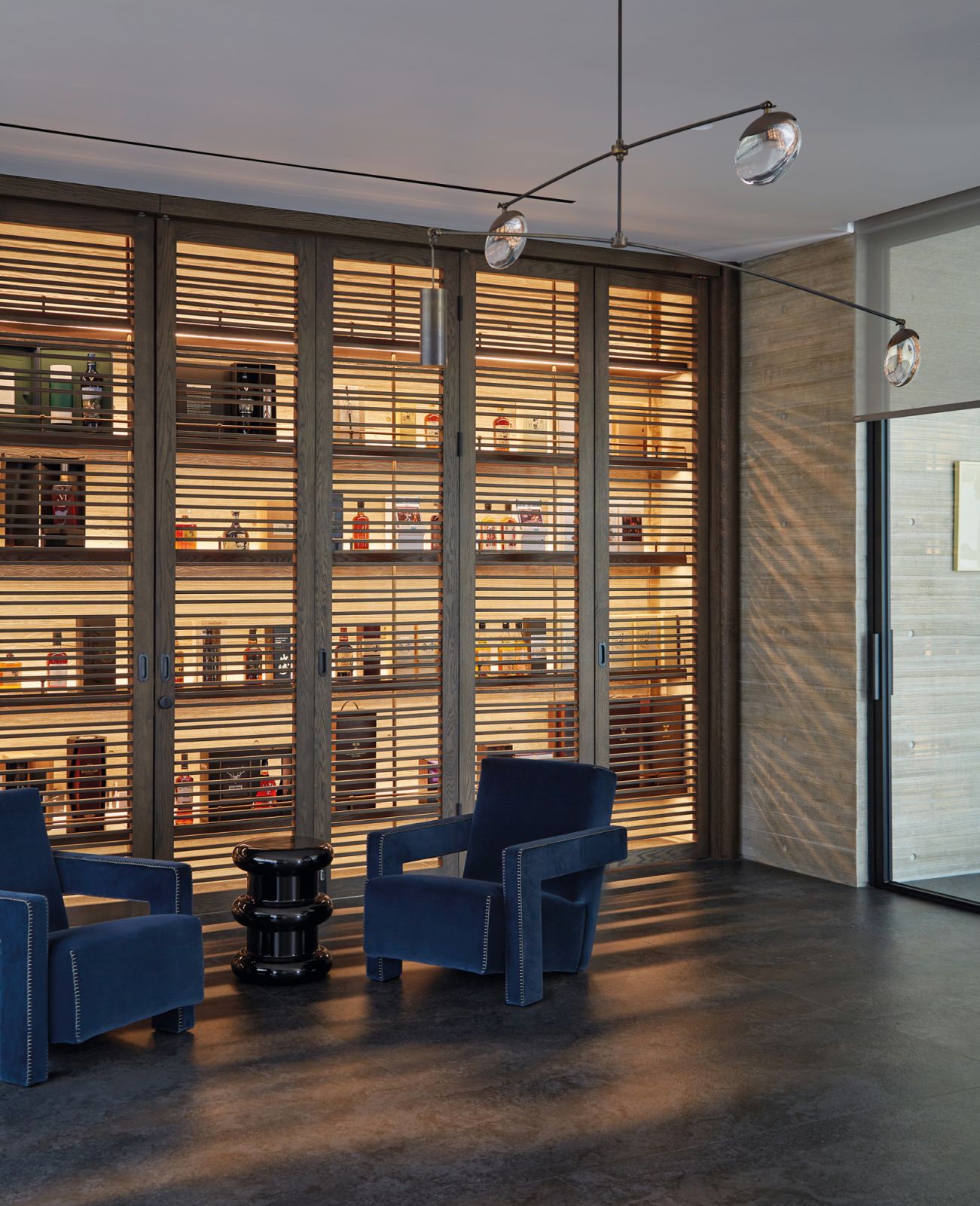 Backlit shelves highlight the husband’s treasured collection of spirits