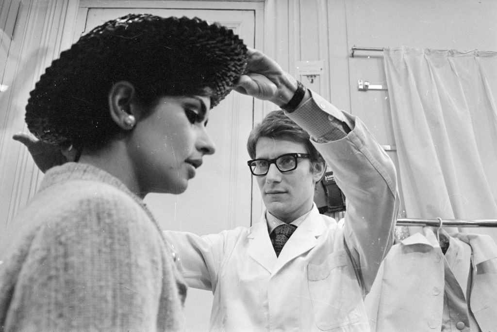 7th April 1965:  Yves Saint-Laurent, ex-wonder boy of Dior, working with a fashion model at his own fashion house in Paris.  (Photo by Reg Lancaster/Express/Getty Images)