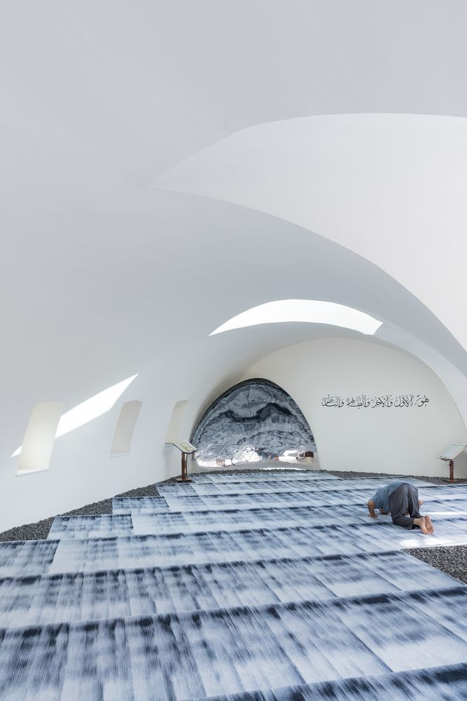 The concave mihrab of polished stainless steel wall (Photo: Iwan Baan via @leftarchitects / Instagram)