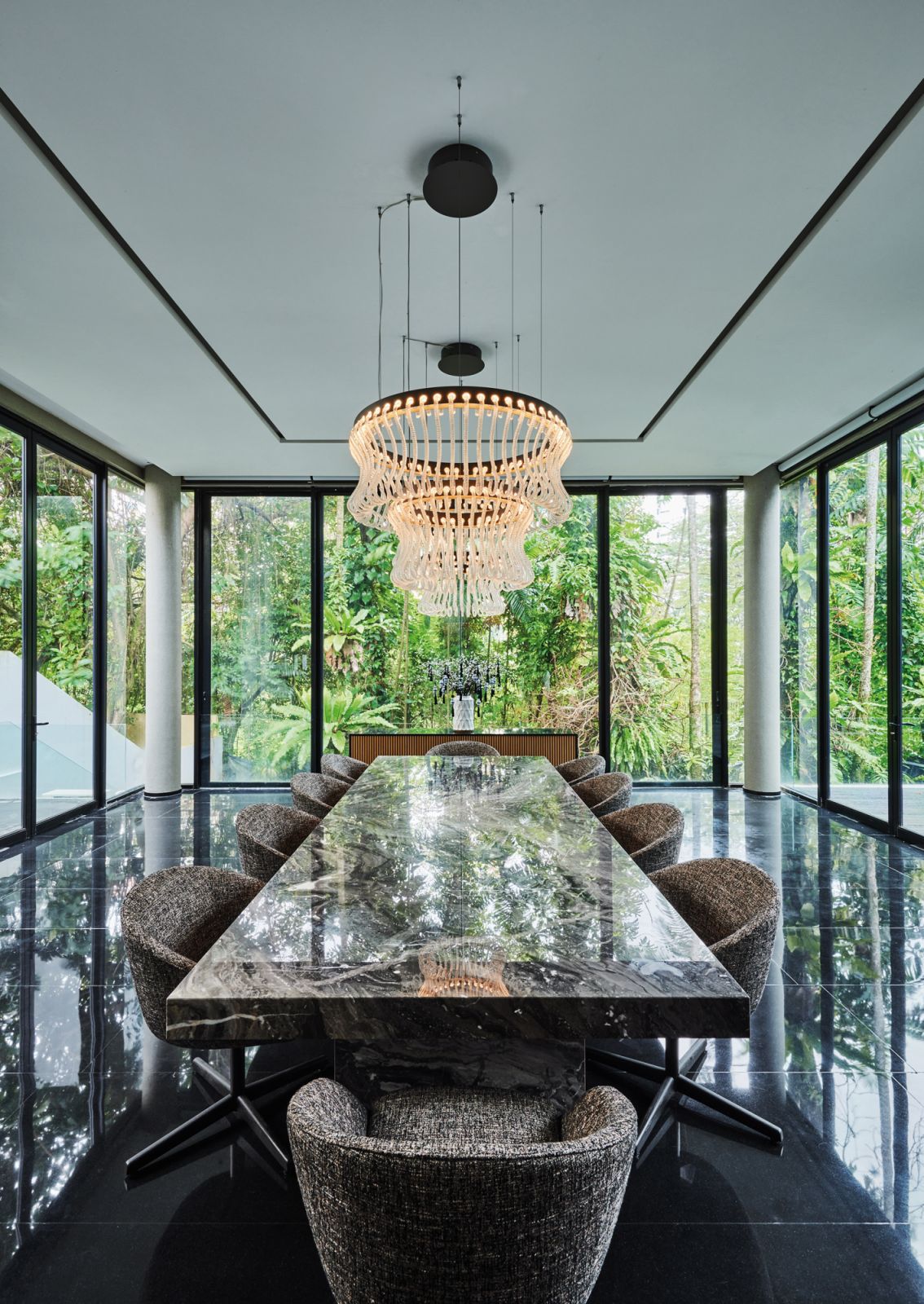 The majestic dining hall features the home’s original polished granite flooring, a bespoke marble table, Minotti dining chairs and two Crown chandeliers from Barovier & Toso