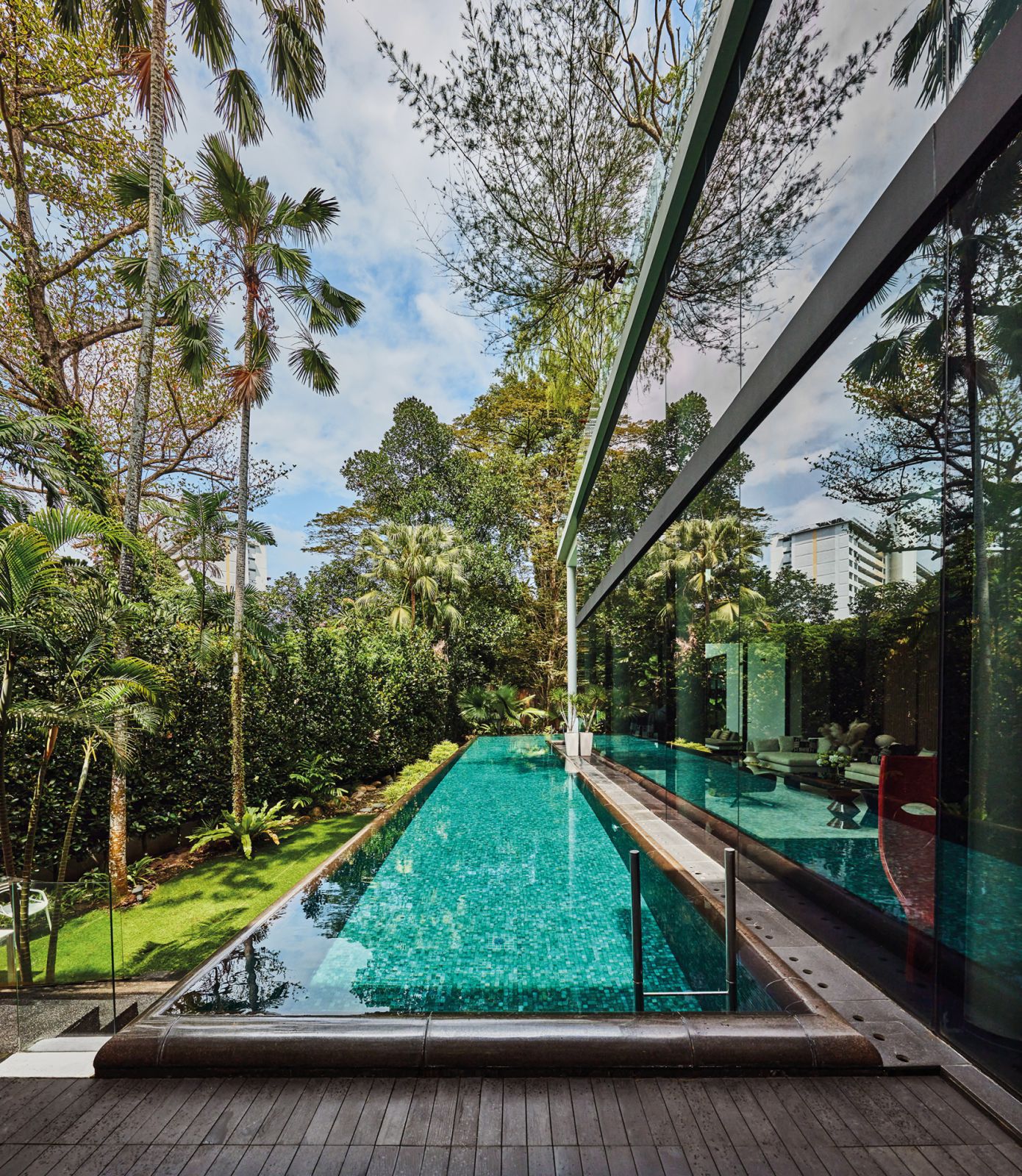 Reflecting the blue and green tones of the outdoors, the double-height windows of the living area also let in copious amounts of natural light