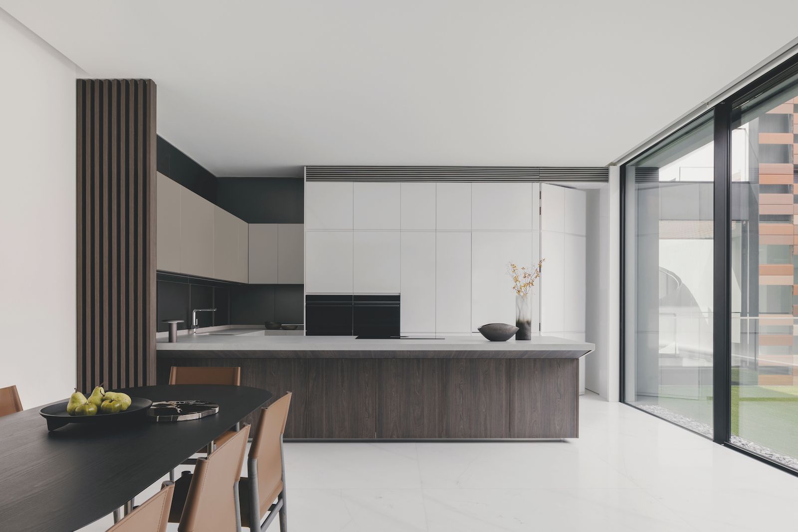 The dry kitchen incorporates a fridge-freezer and CoolDrawer in a minimal finish that matches the sleek wood veneer cabinetry