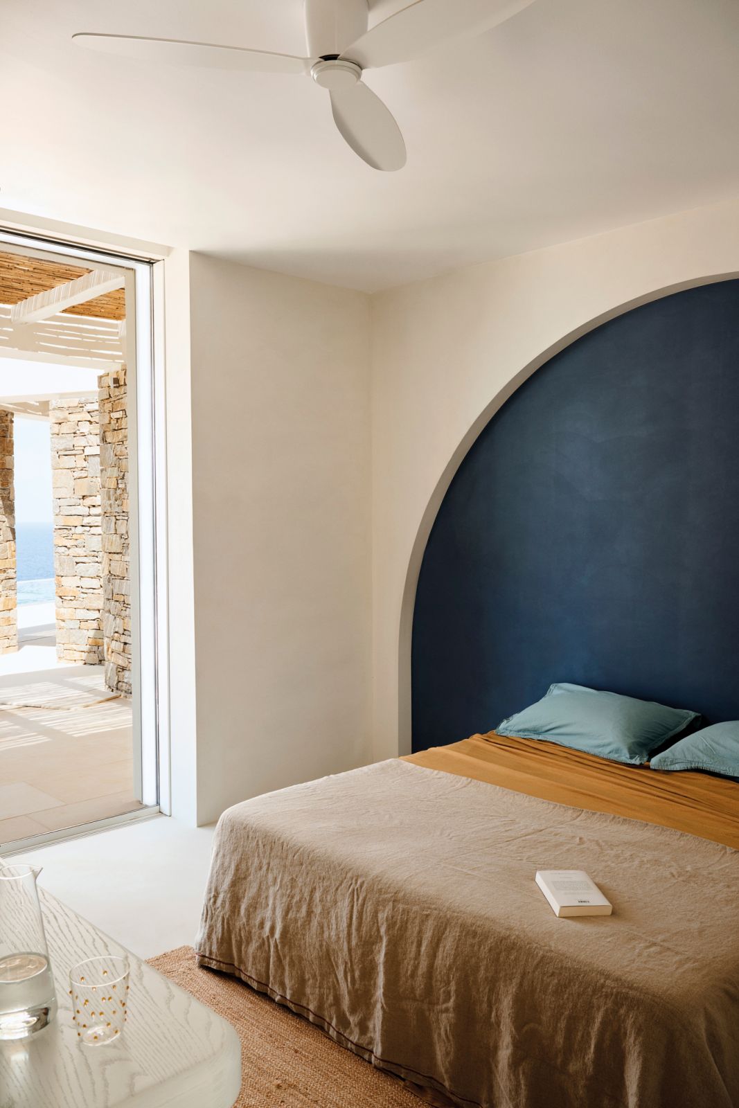 The blue arched recess behind the bed harmonises the interior with the great outdoors