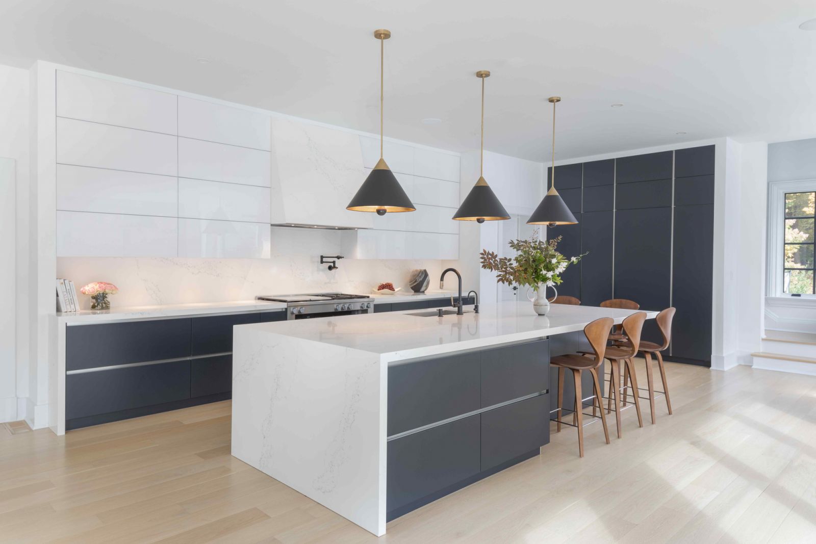 The contemporary kitchen with light wood flooring
