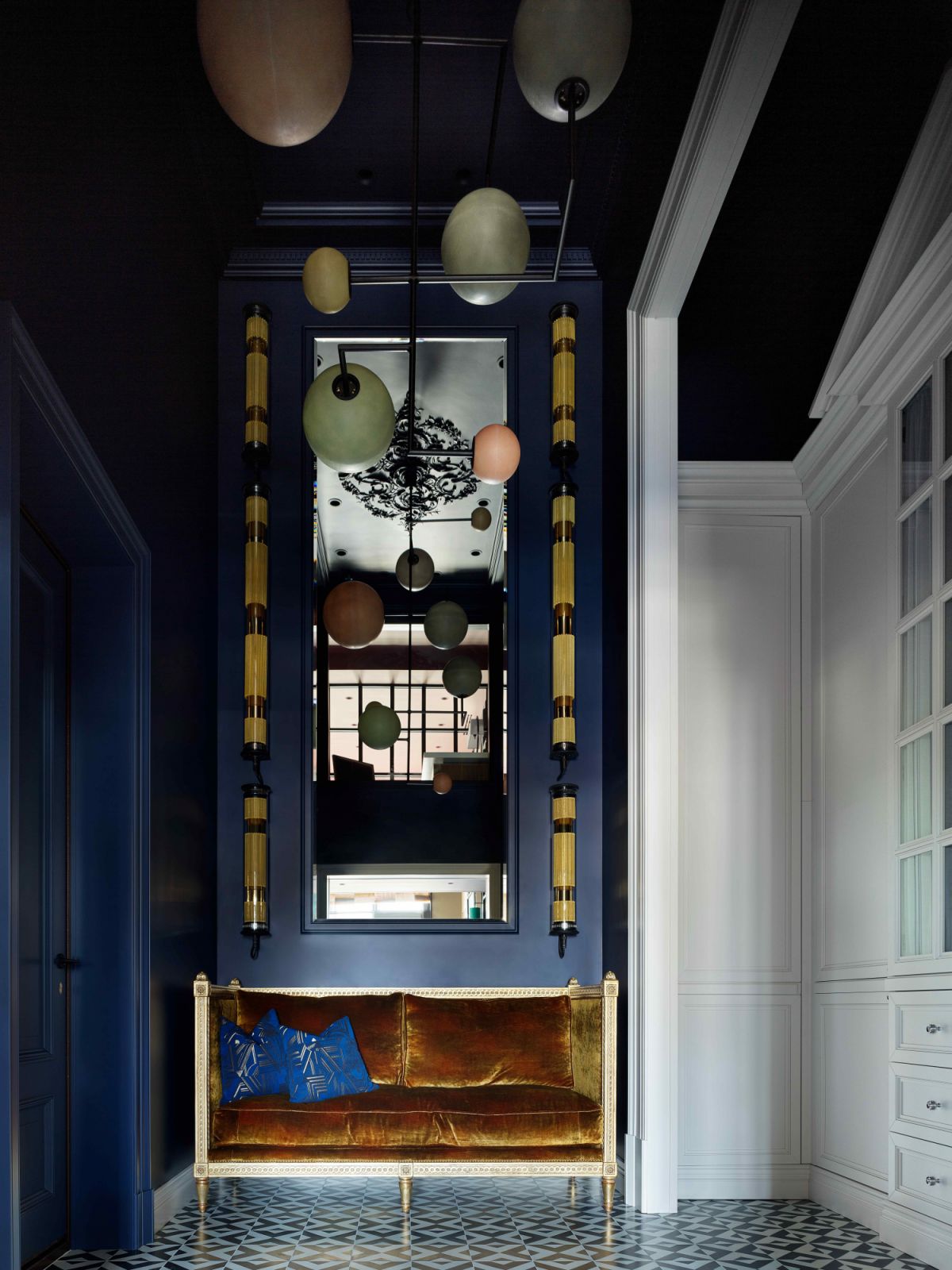 The dark blue entry hall with matching wall lights and fabrics