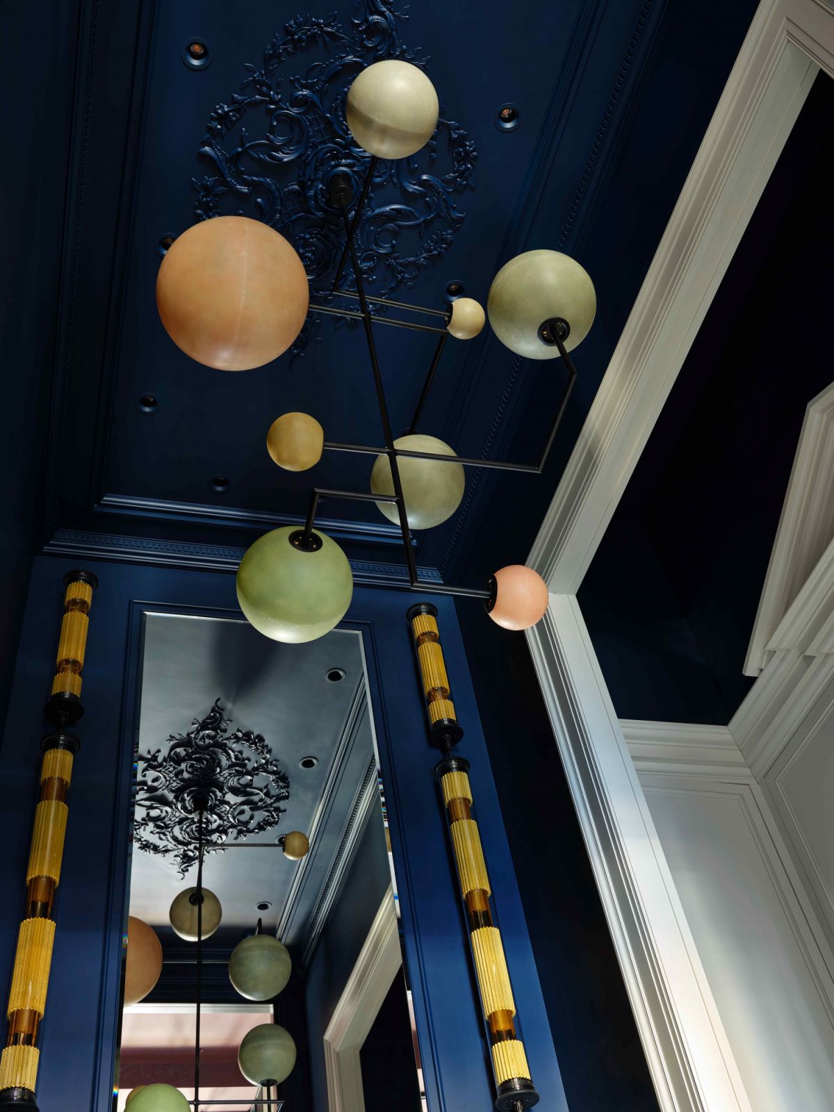 The Dimorestudio chandelier hangs off an ornate moulding