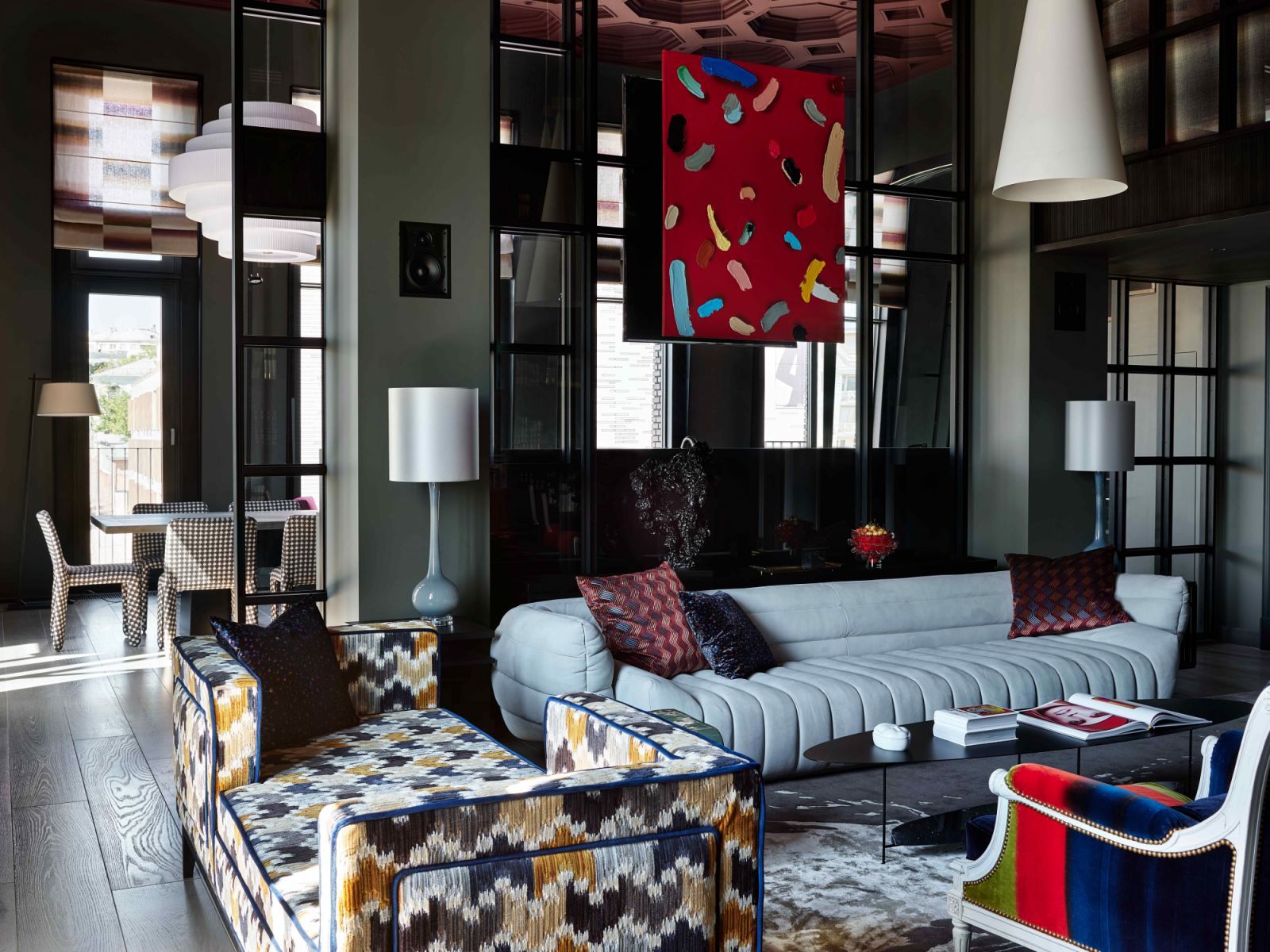 Industrial-style wall partitions and panelled glass doors divide the living room from the kitchen and dining areas