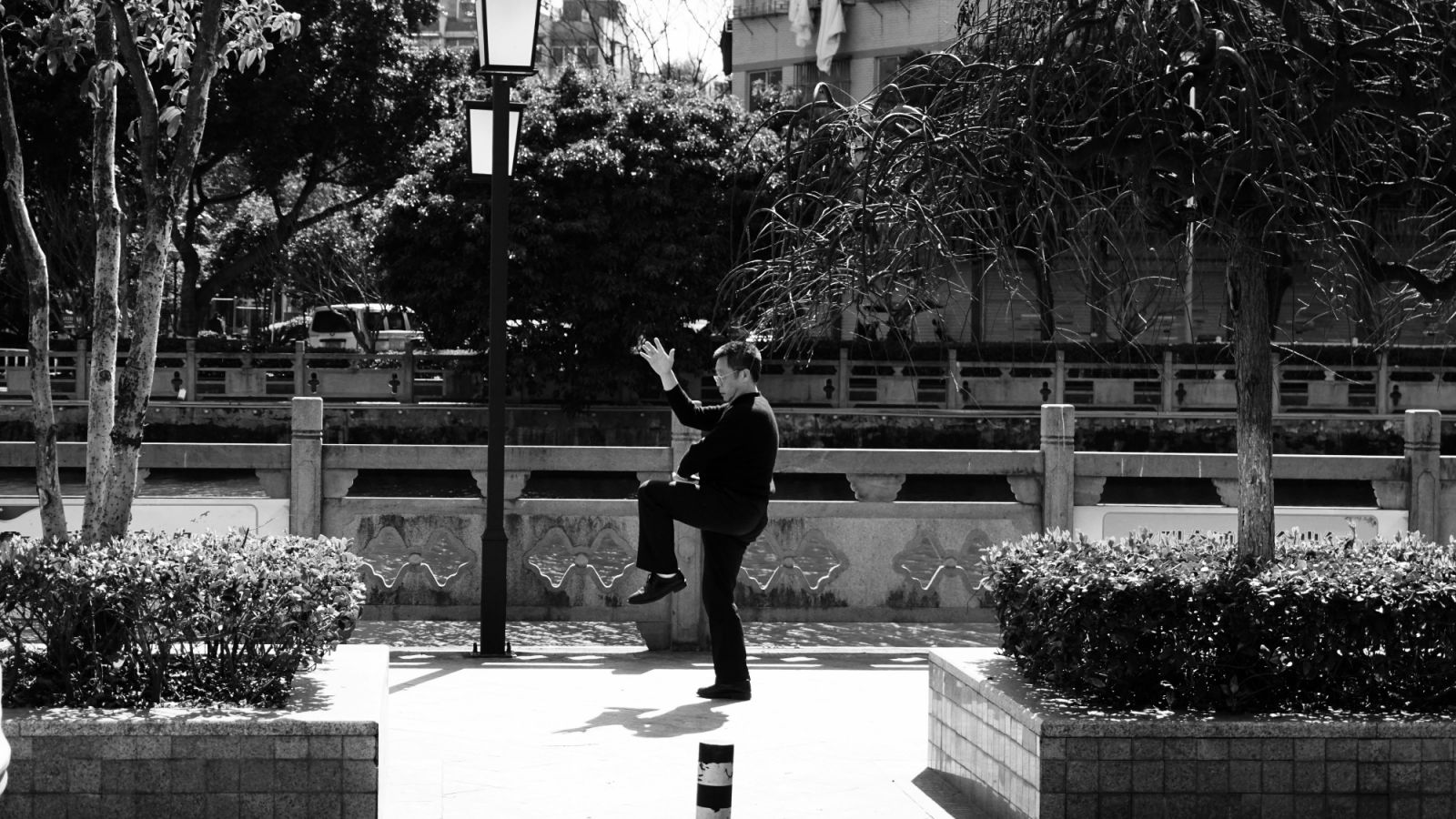 Black and white photo of a man exercising tai chi in a city (Photo: Wes Chuan / Pexels)