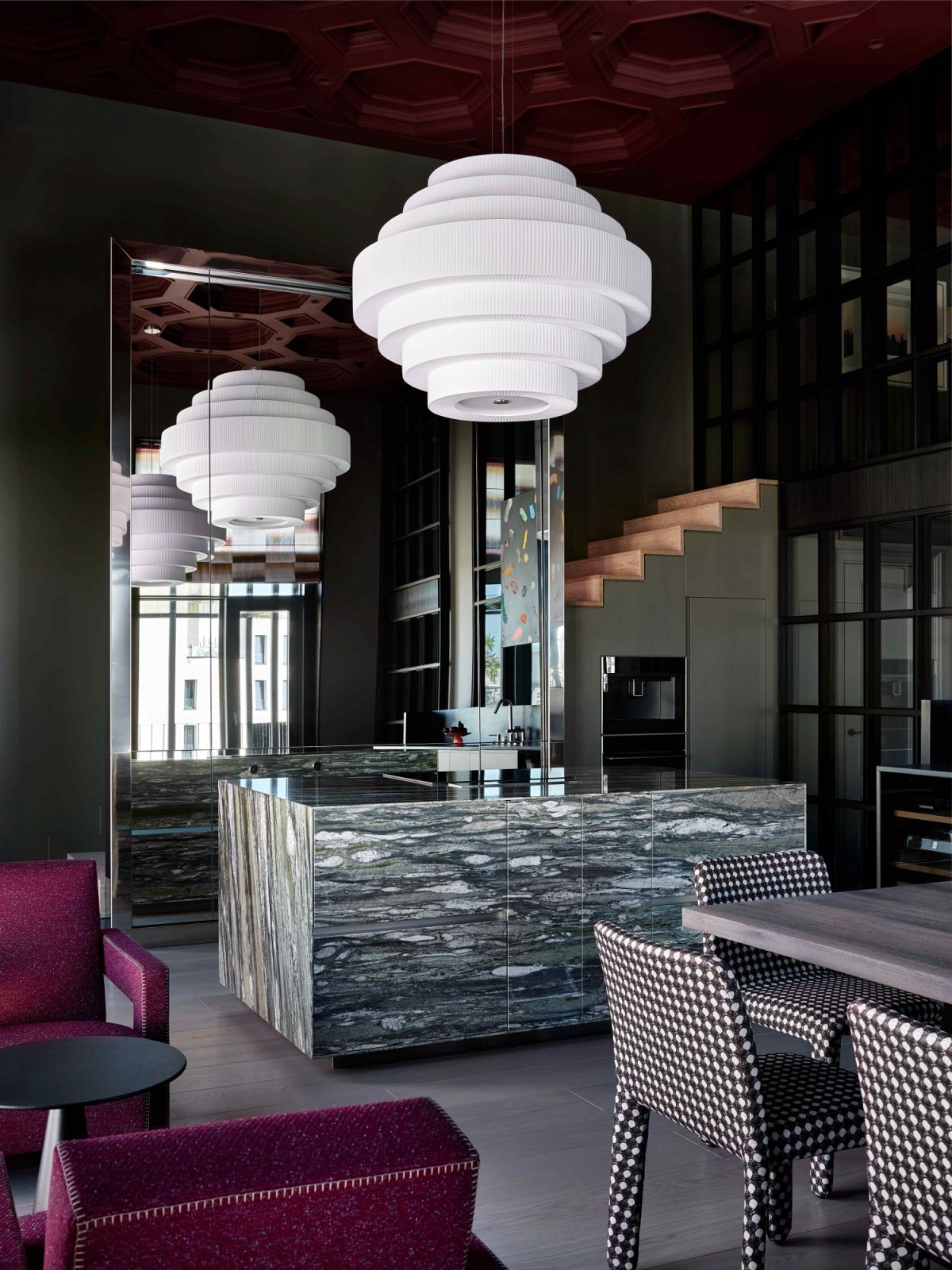 A marble island centrepiece underneath the burgundy ceiling