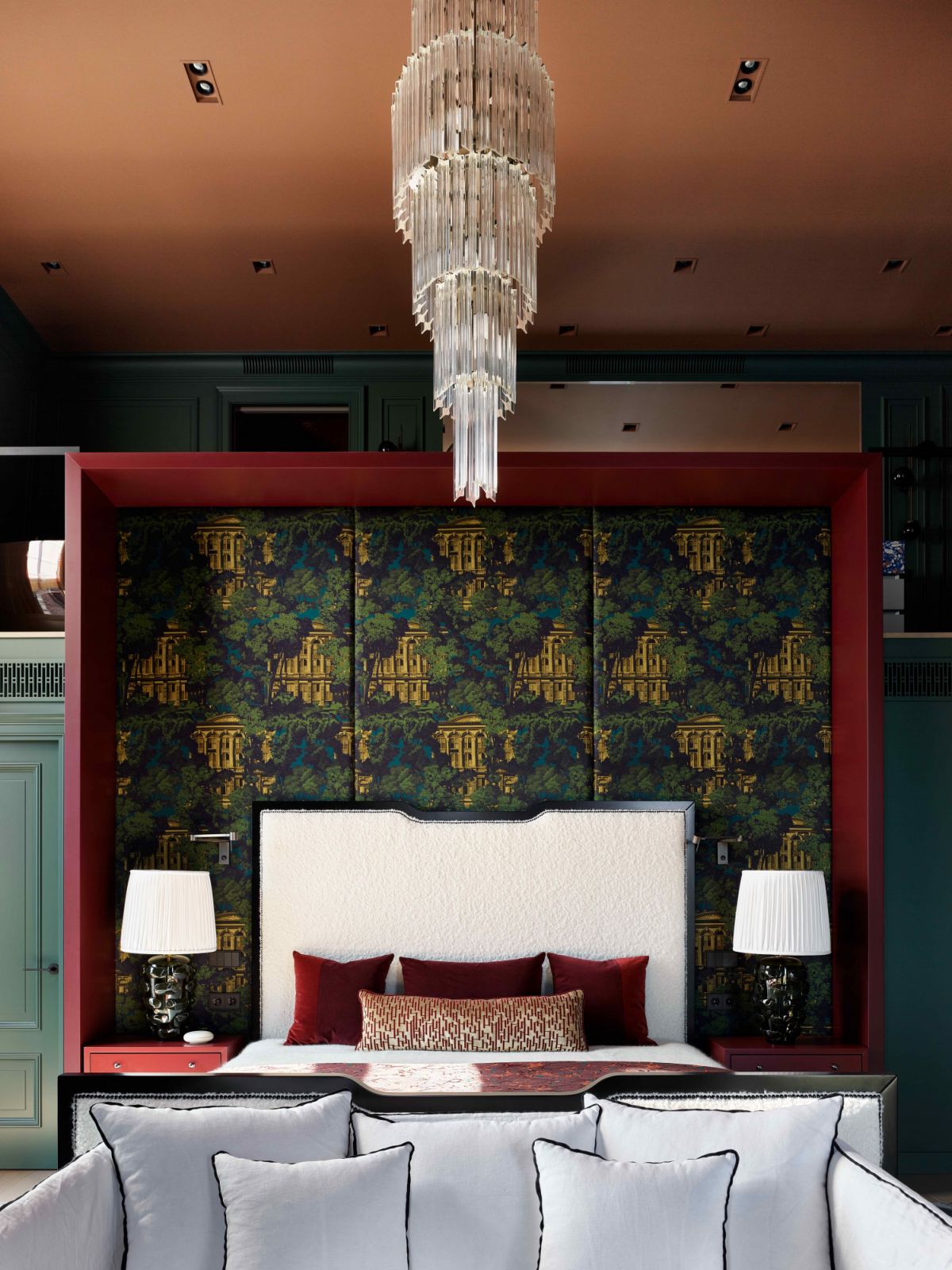 The opulent and rich-coloured main bedroom suite with an overhanging chandelier