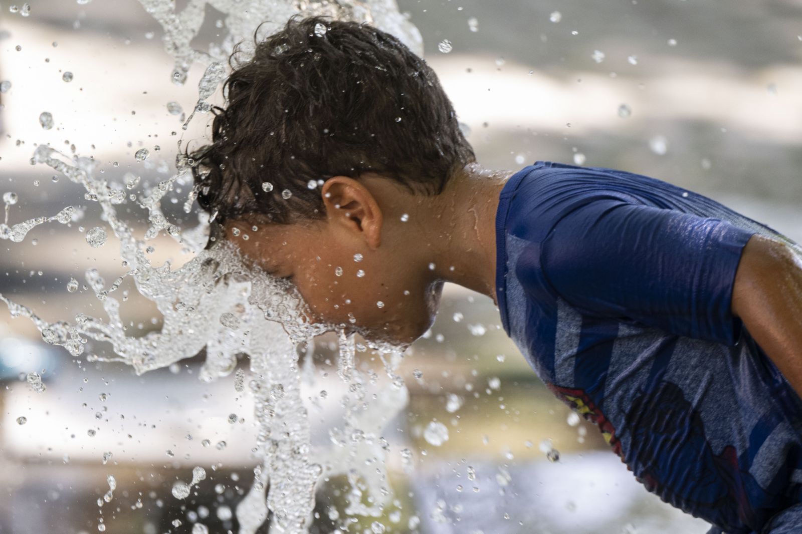 ANKARA, TURKIYE - JULY 16: A child holds water from a fountain on his face to cool off at Kugulu Park in capital Ankara, Turkiye on July 16, 2023. (Photo by Binnur Ege Gurun Kocak/Anadolu Agency via Getty Images)