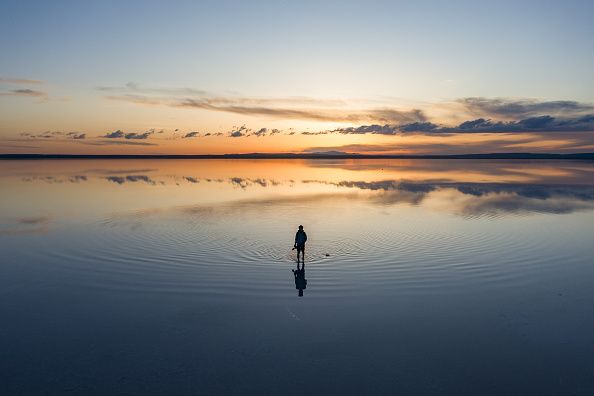 ANKARA, TURKIYE - APRIL 22: An aerial view of a man standing on Lake Tuz, Turkiye's second largest lake, during sunset in Ankara, Turkiye on April 22, 2024. The lake, which is on the UNESCO World Heritage Tentative List with its unique natural structure, welcomes many local and foreign tourists every year as it provides 70 per cent of the country's salt needs. (Photo by Hakan Nural/Anadolu via Getty Images)