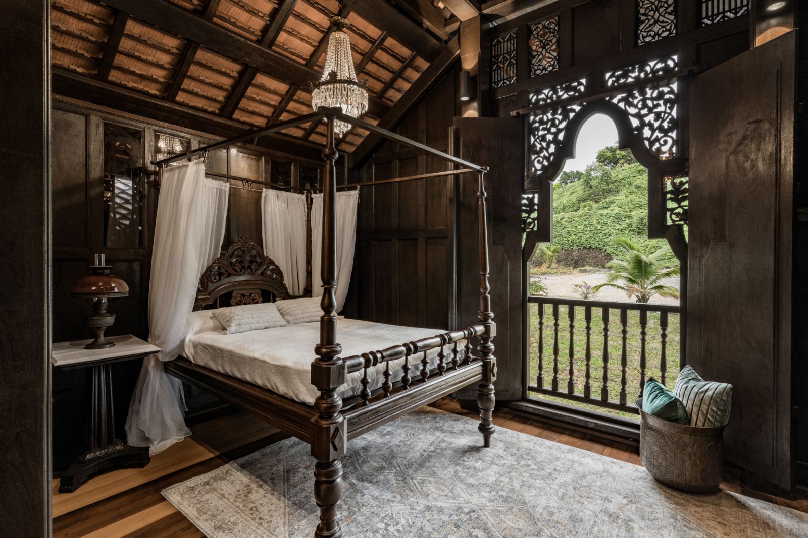 The main bedroom has a romantic feel with a carved four-poster bed