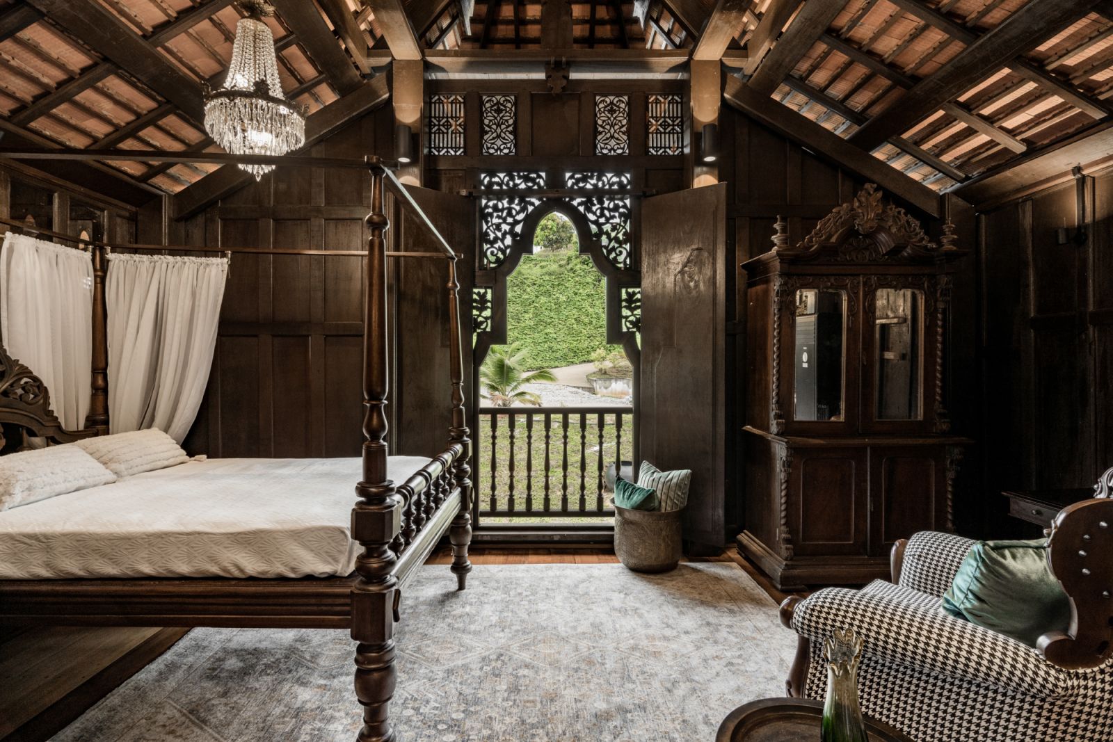 The main bedroom has a romantic feel with a carved four-poster bed