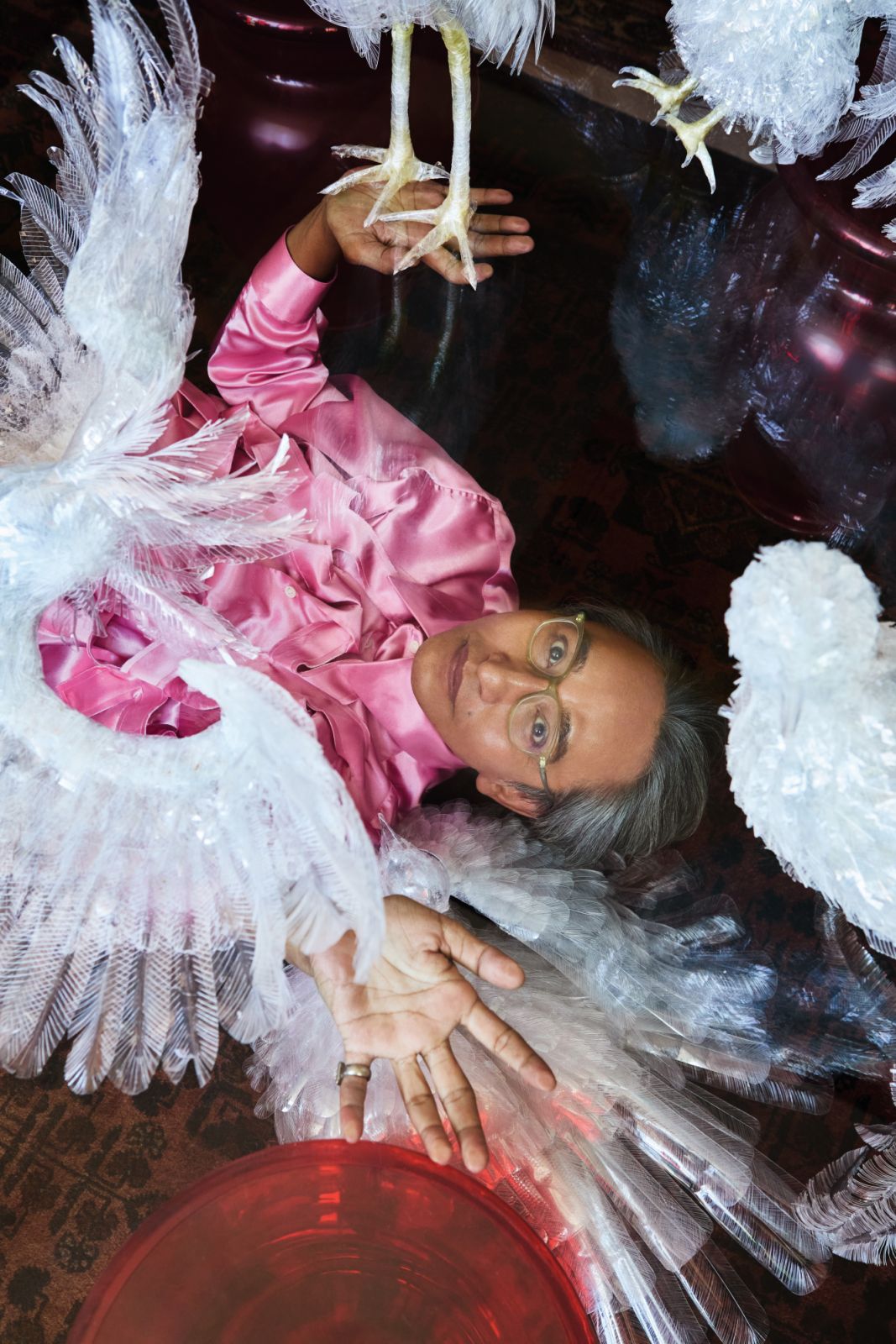 Raja Malek surrounded by his “birds” crafted from plastic waste. Comme des Garçons shirt, from Club 21 Multilabel