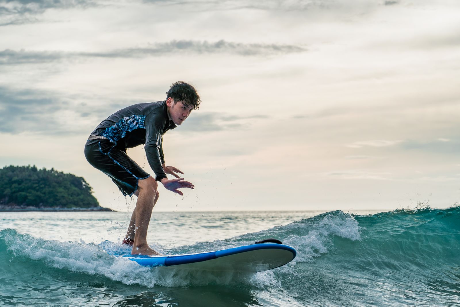 A man in a bathing suit is surfing in the sea