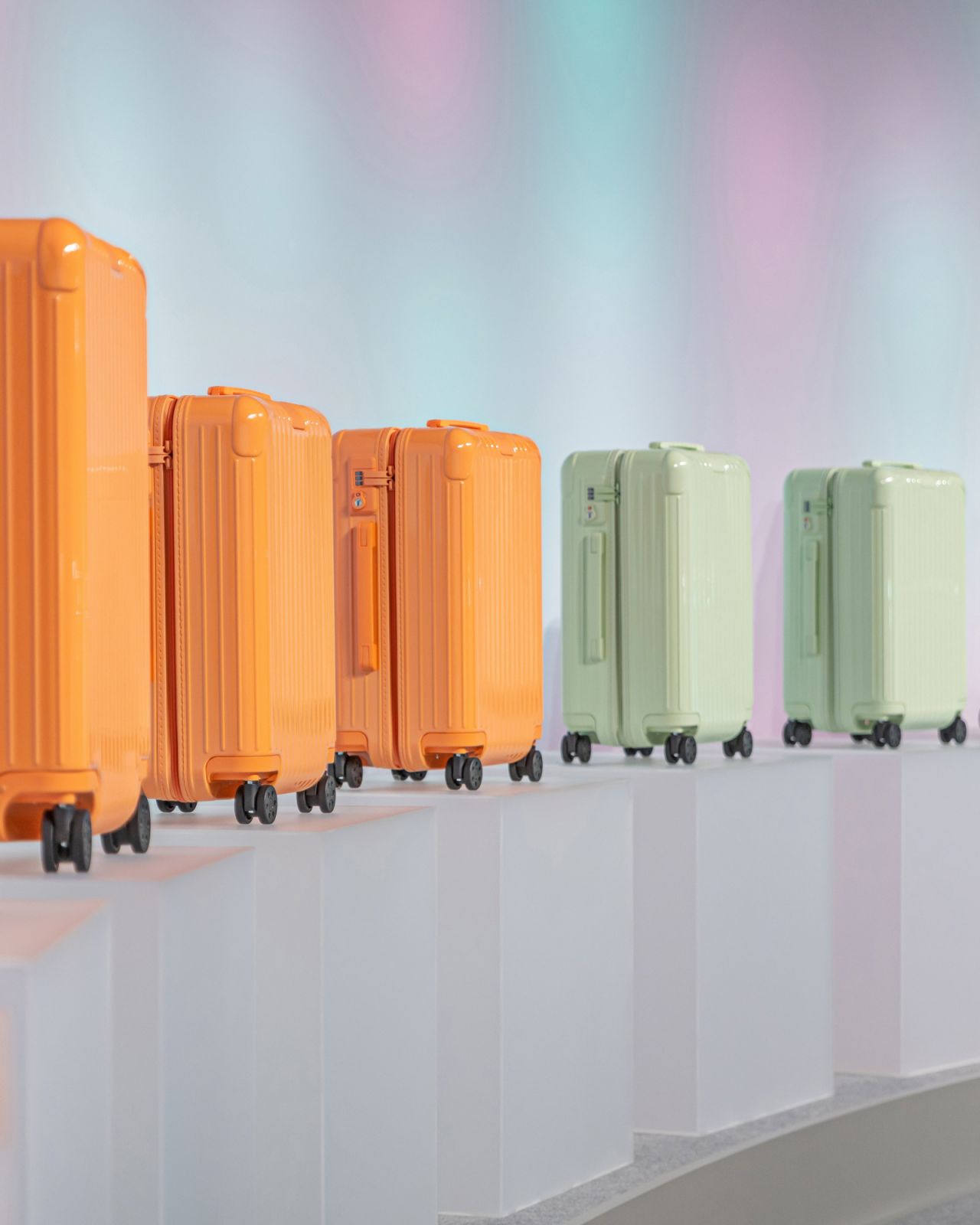 An array of min and papaya luggages on display