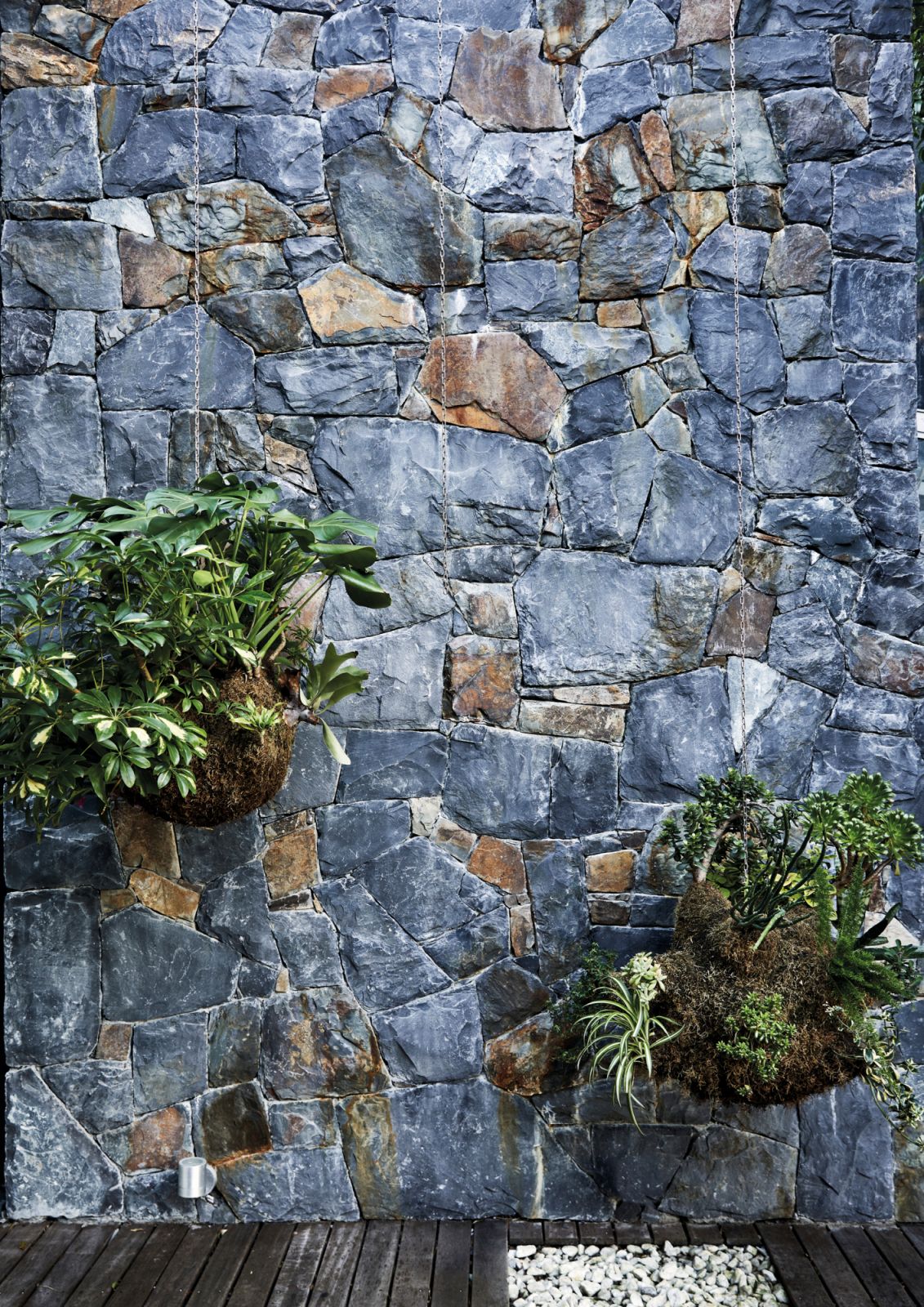 These hanging plants pair well with the stone wall