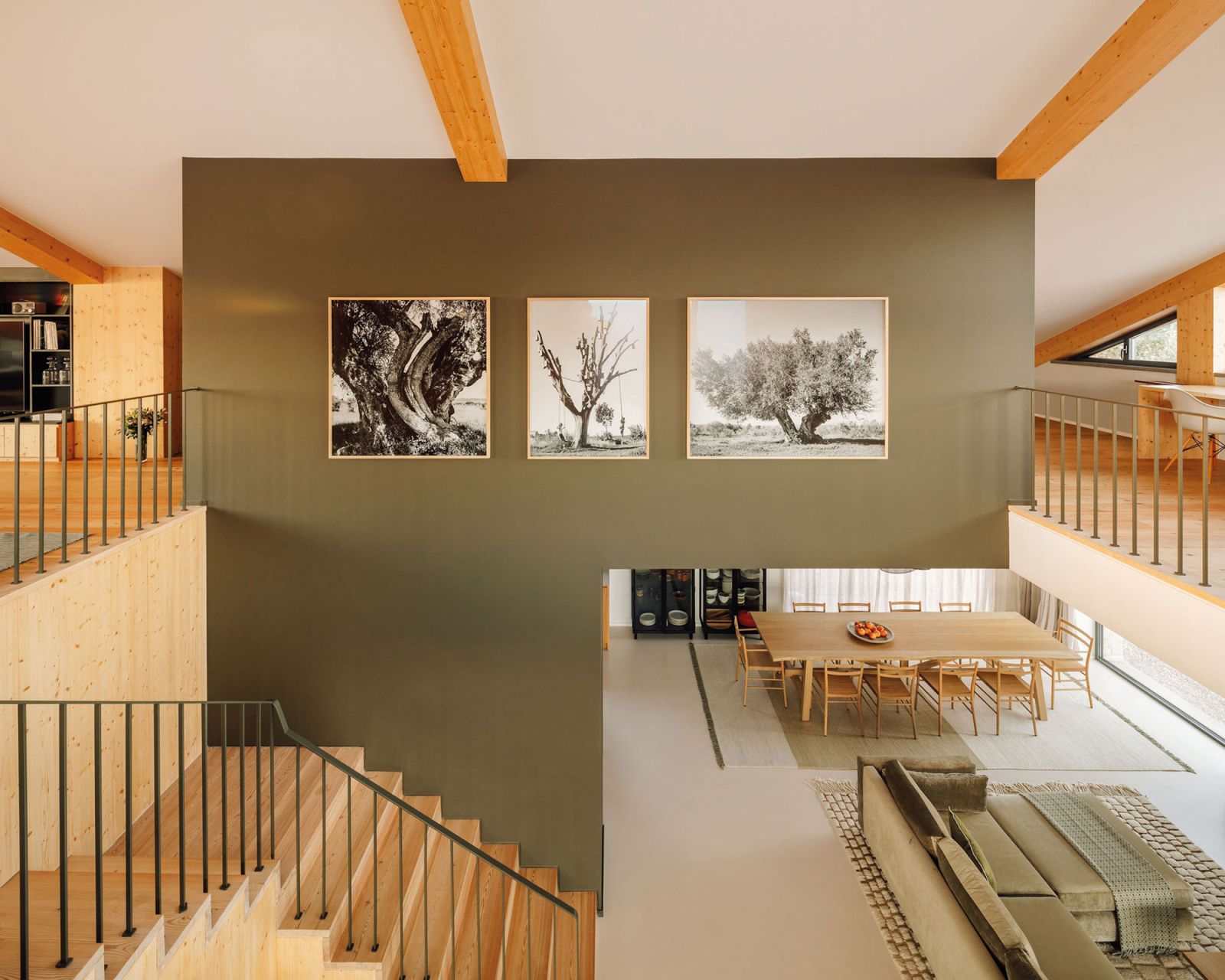 A wall painted in a bold hue serves to visually link the first floor with the mezzanine level