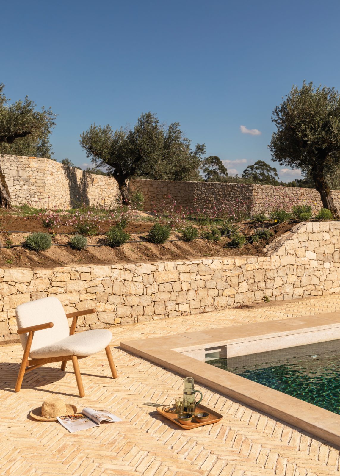 The deep-green mosaics of the swimming pool and the sandy-toned terracotta tiles mirror the home’s surrounding environment beautifully