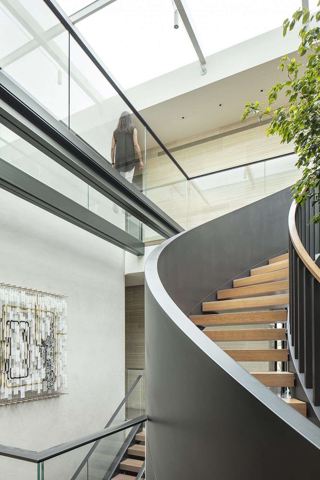 A clear glass walkway links the private spaces underneath a large skylight