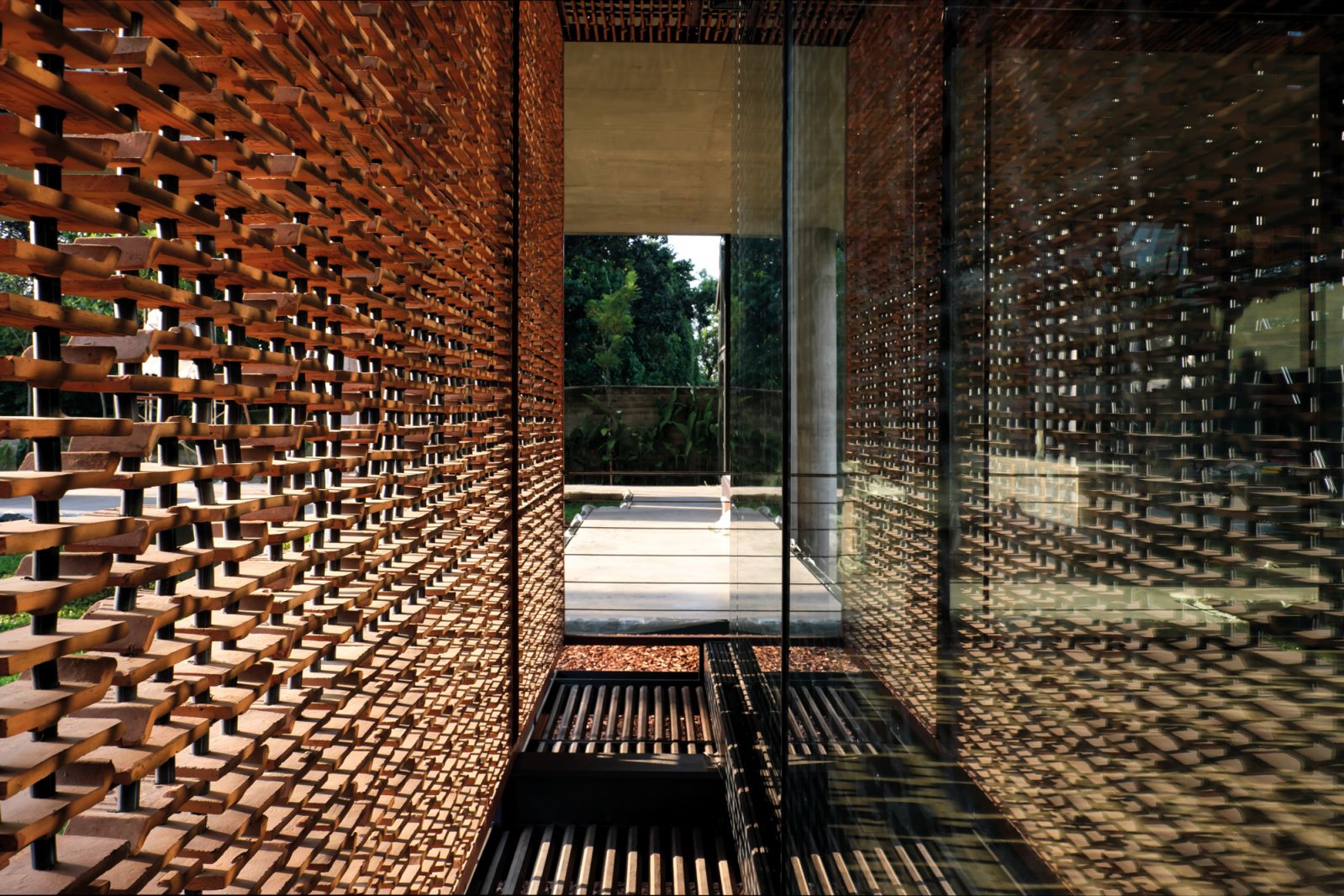 This west-facing corridor is layered with a screen made up of cleverly cut terracotta roof tiles