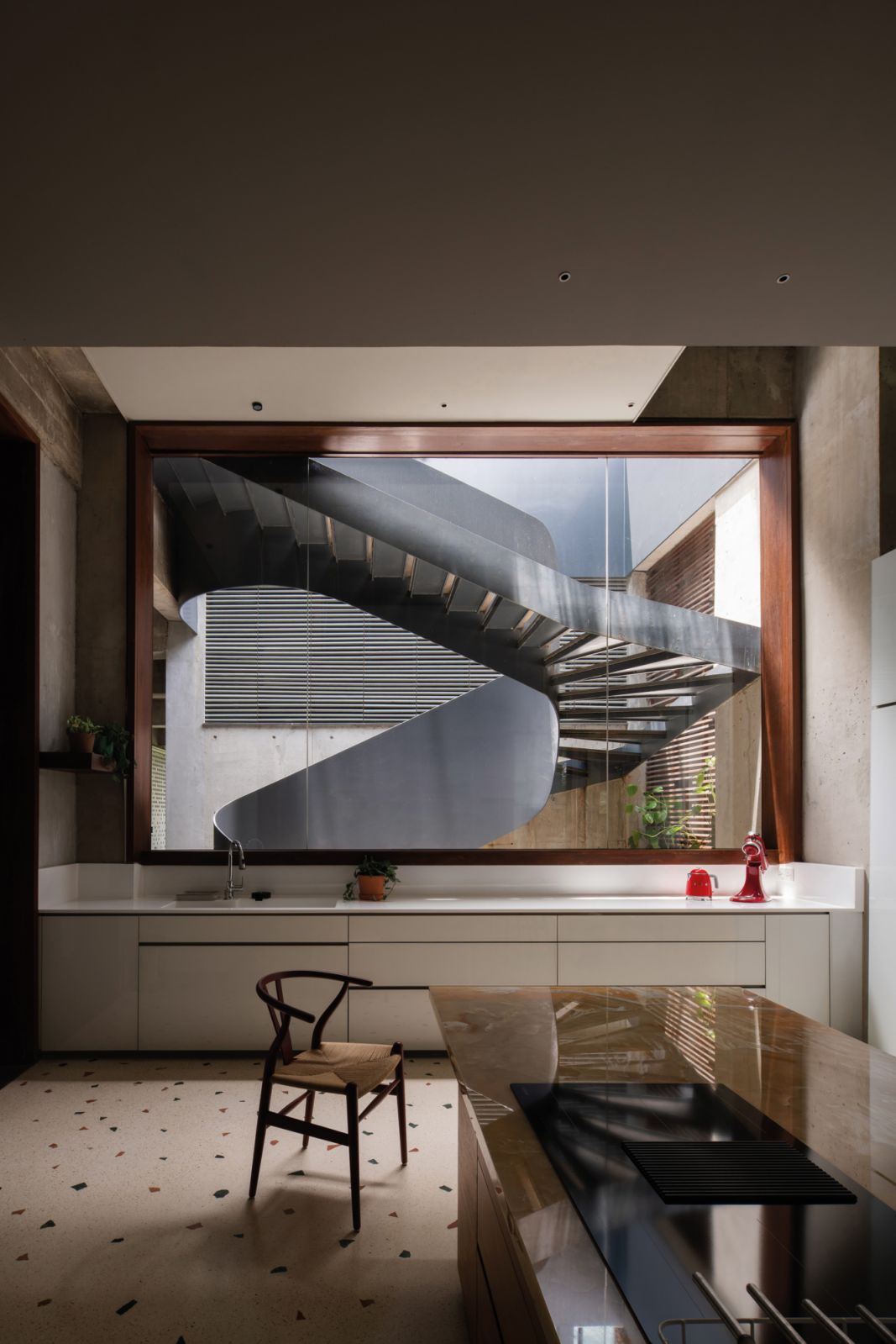 The spiral staircase makes a sculptural statement from this vantage point in the dry kitchen