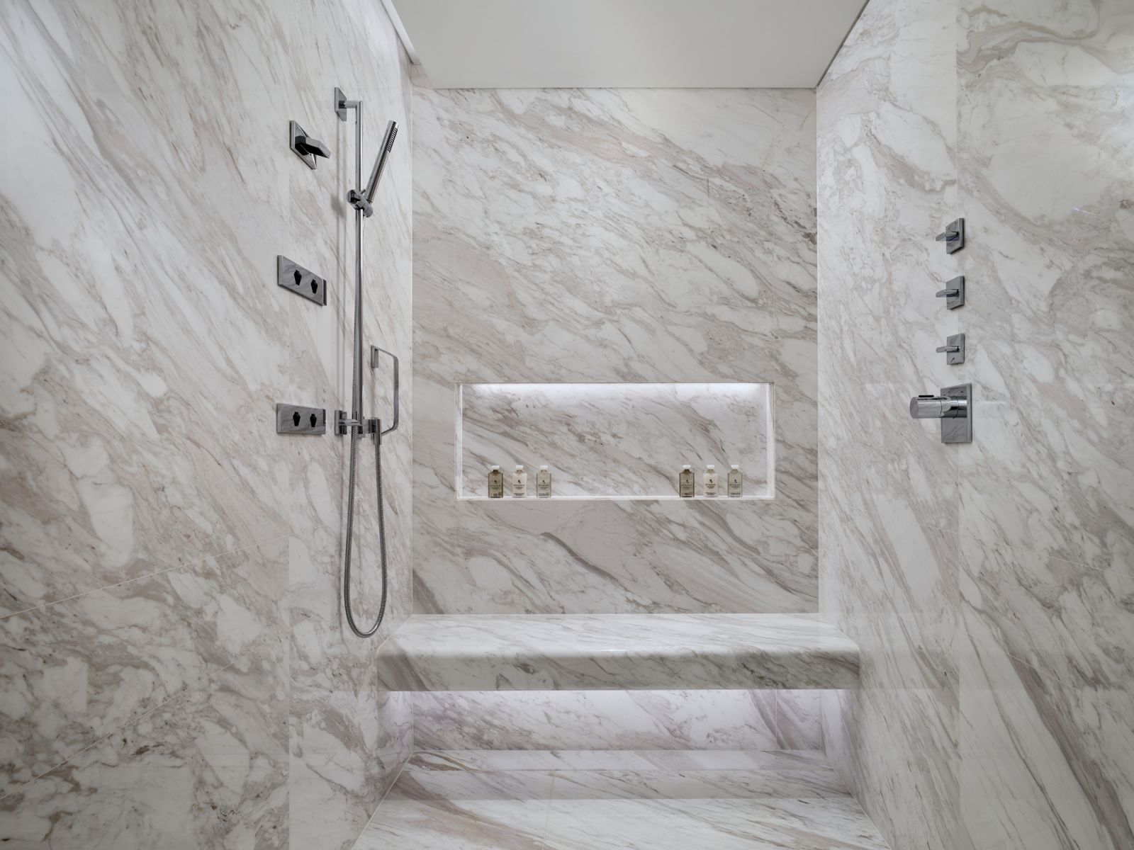 Bathroom features side shower massage jets with rain shower and bench