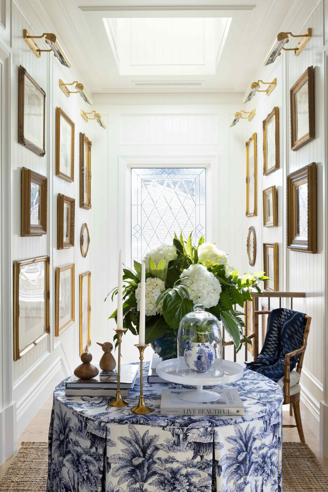 Family photos in antique frames line the double-height gallery wall