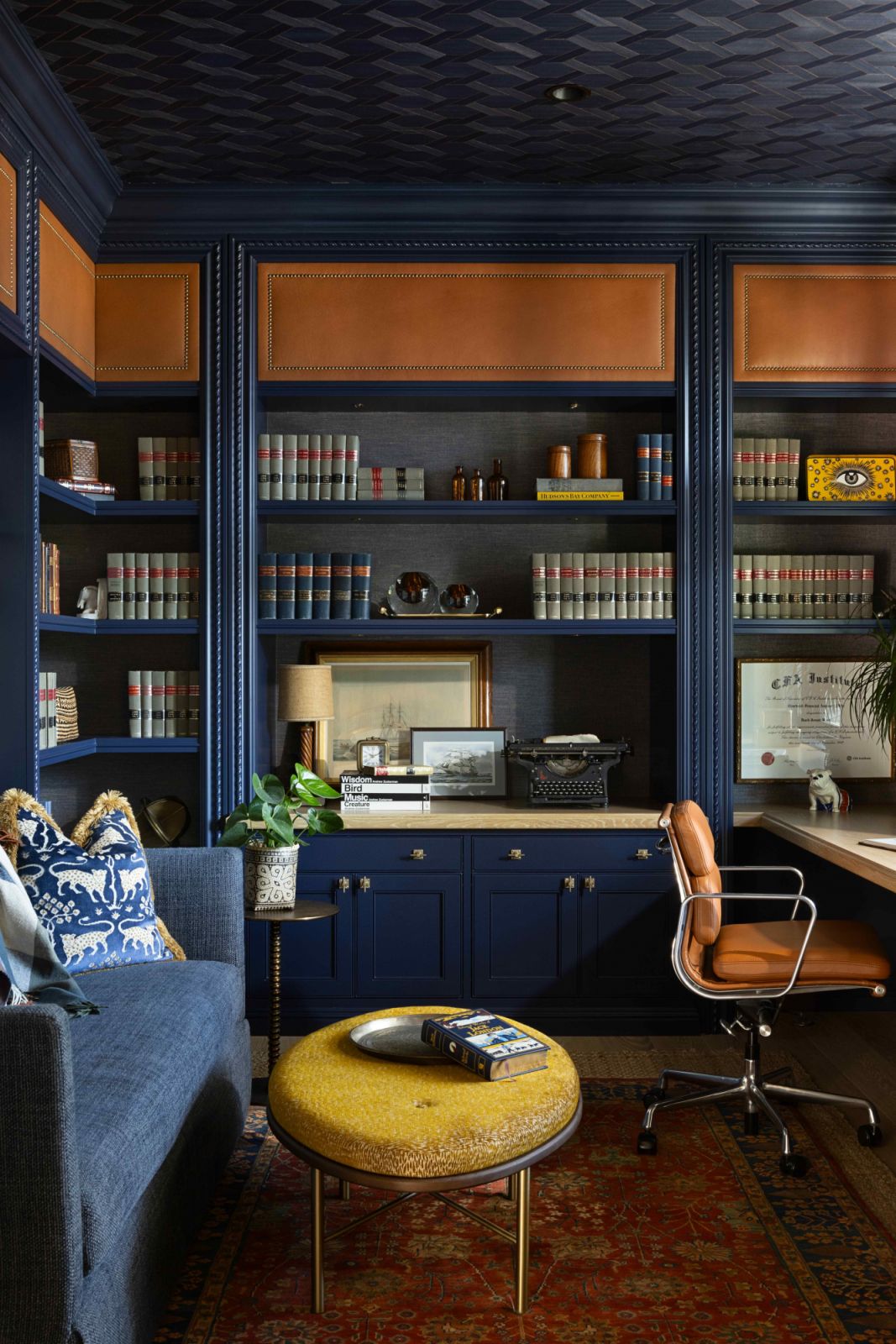 The office with navy millwork and cognac leather accents