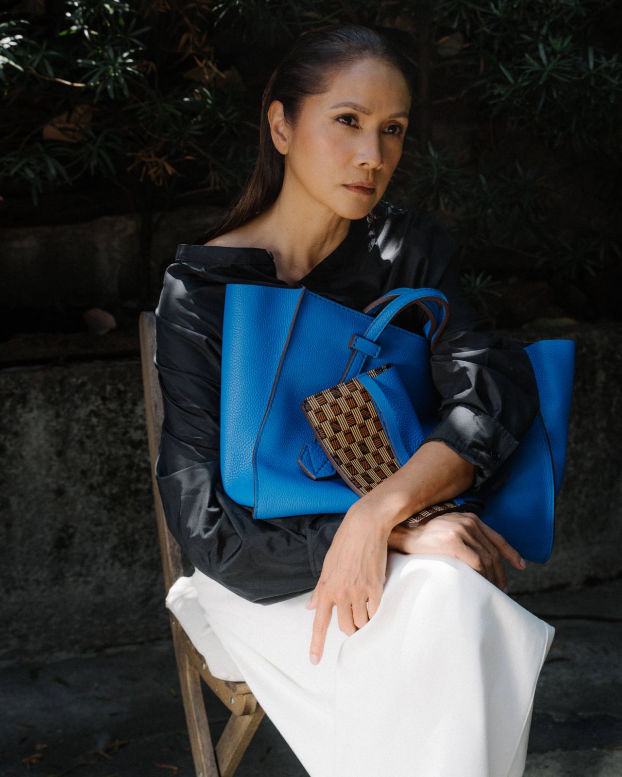 Isidro wears a Lemaire soft collar blouse, Fforme Anu ankle pants and Moreau Brégançon Zip MM bag