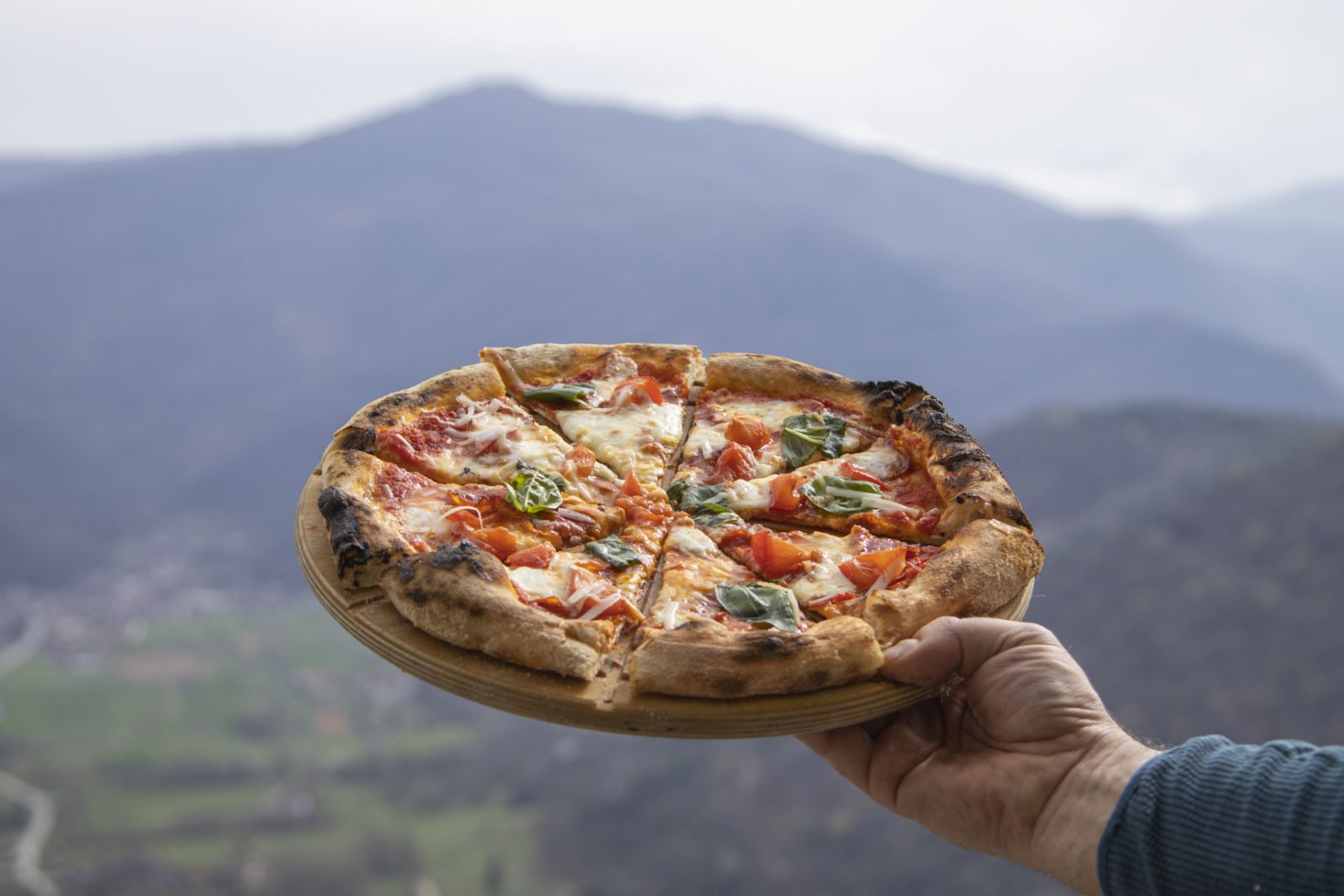 Full frame shot of freshly baked original italian pizza with mountains in the background