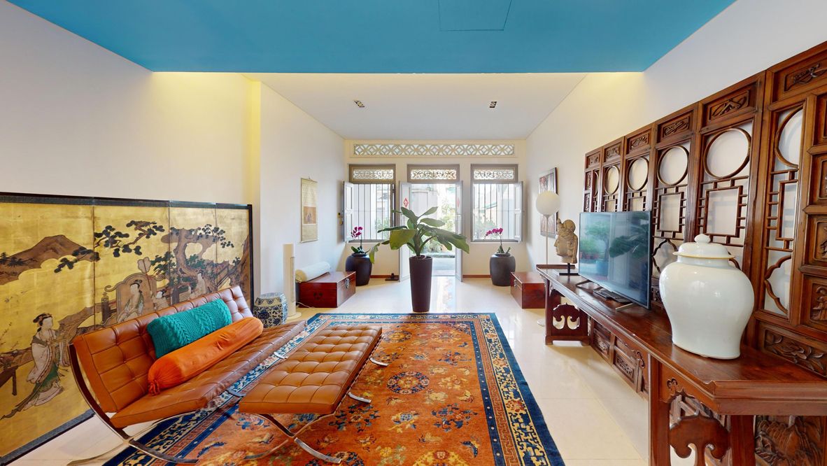 A living room incorporating Chinese coin carvings and art pieces from the owner's collection evokes a blend of heritage and modernity