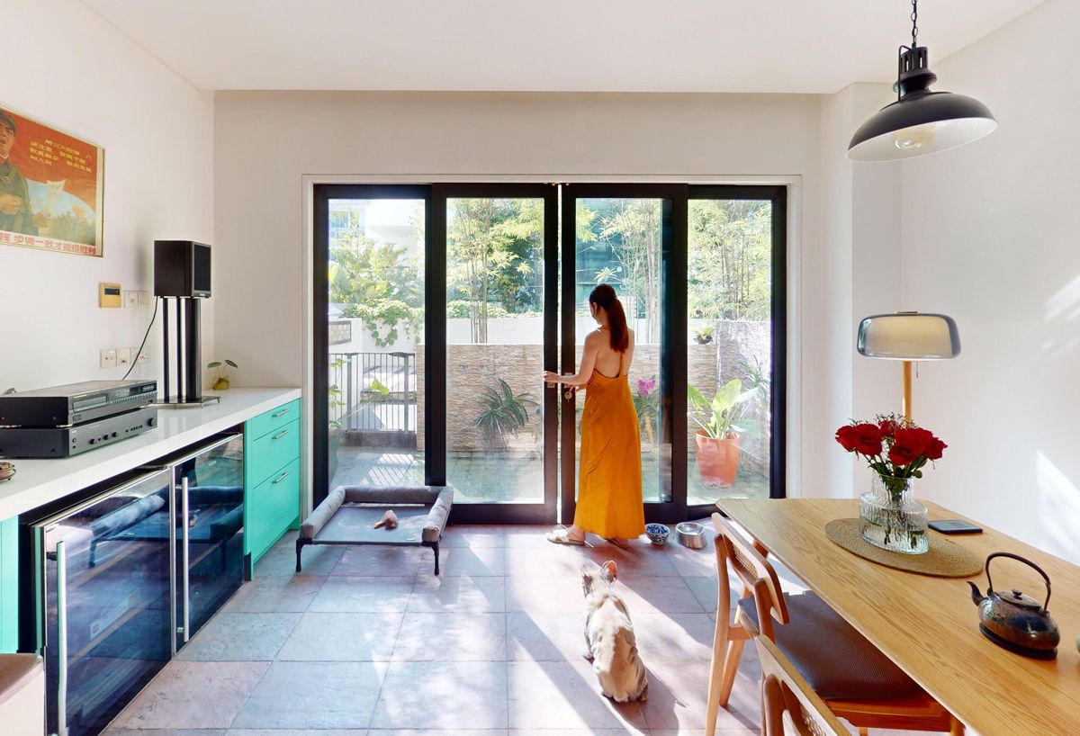 The kitchen's surroundings includes lush plants and verdant green tiles
