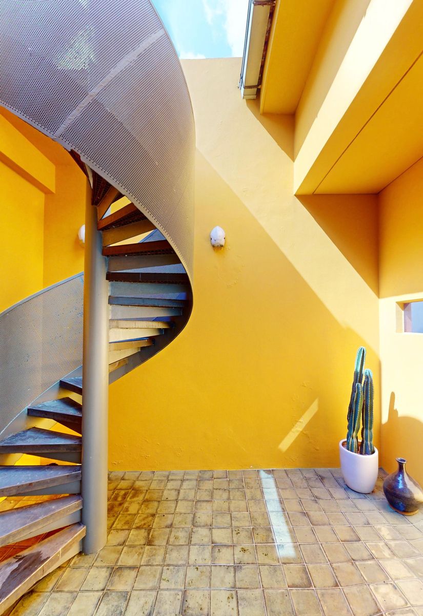 The rooftop courtyard housing a spiral staircase leading to the roof garden is painted a vibrant saffron