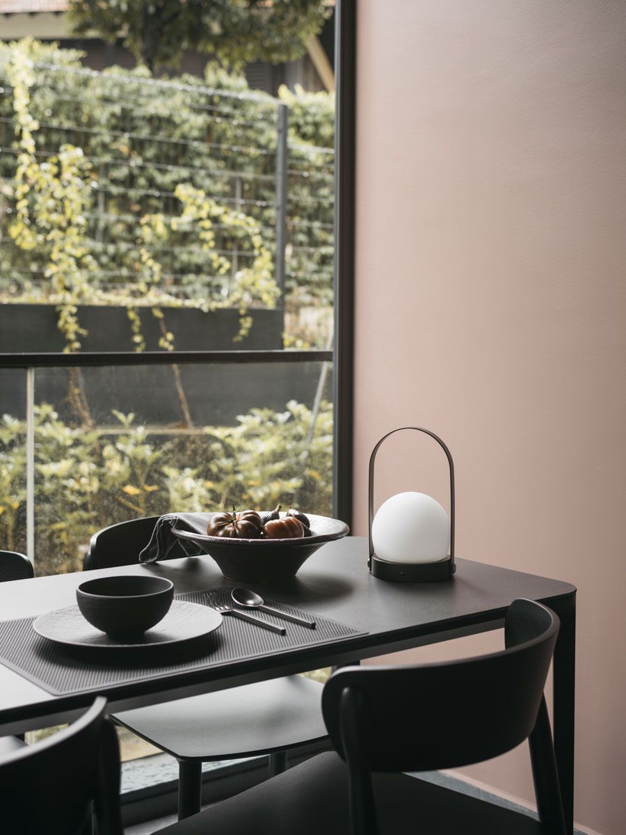 The balcony houses a four-seater dining table that looks out to verdant foliage