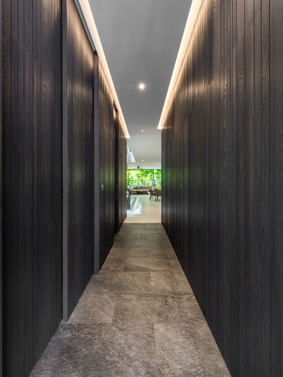 The sleek corridor features wood and stone textures