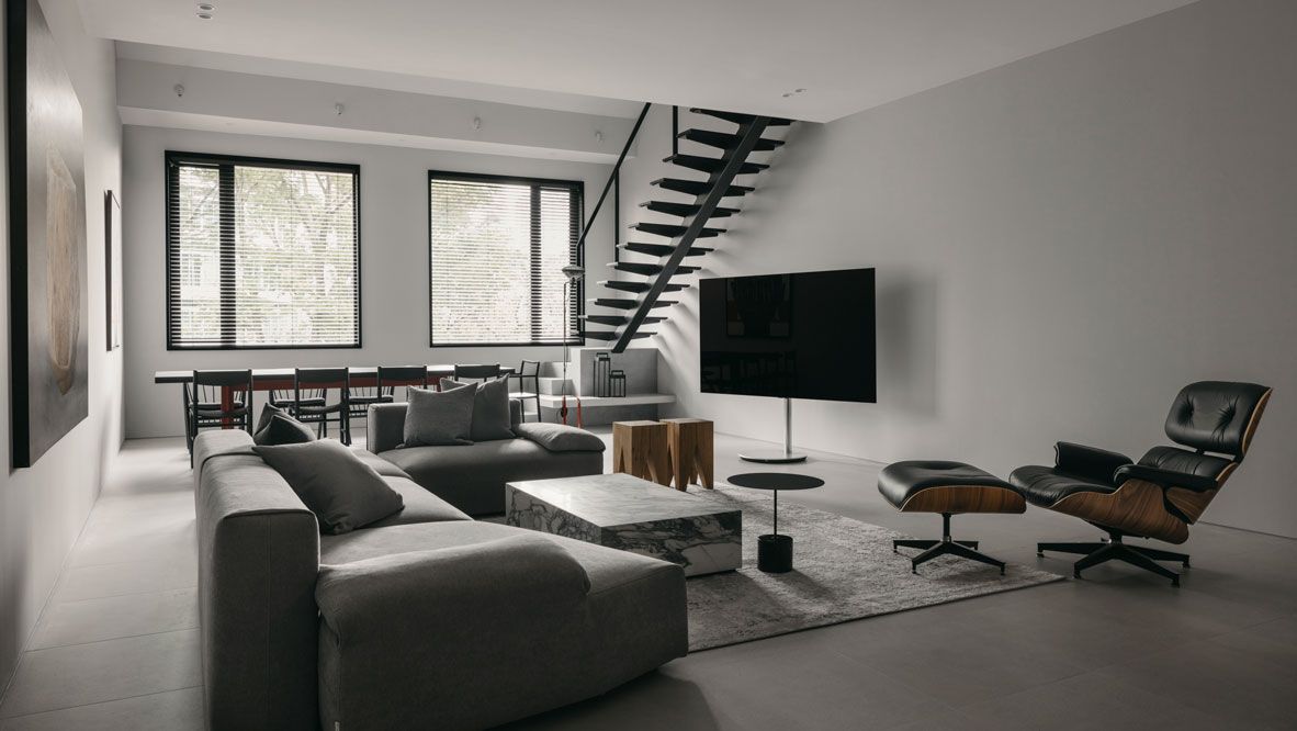 The neutral palette and tactile materials present a serene ambience in the open-plan living room