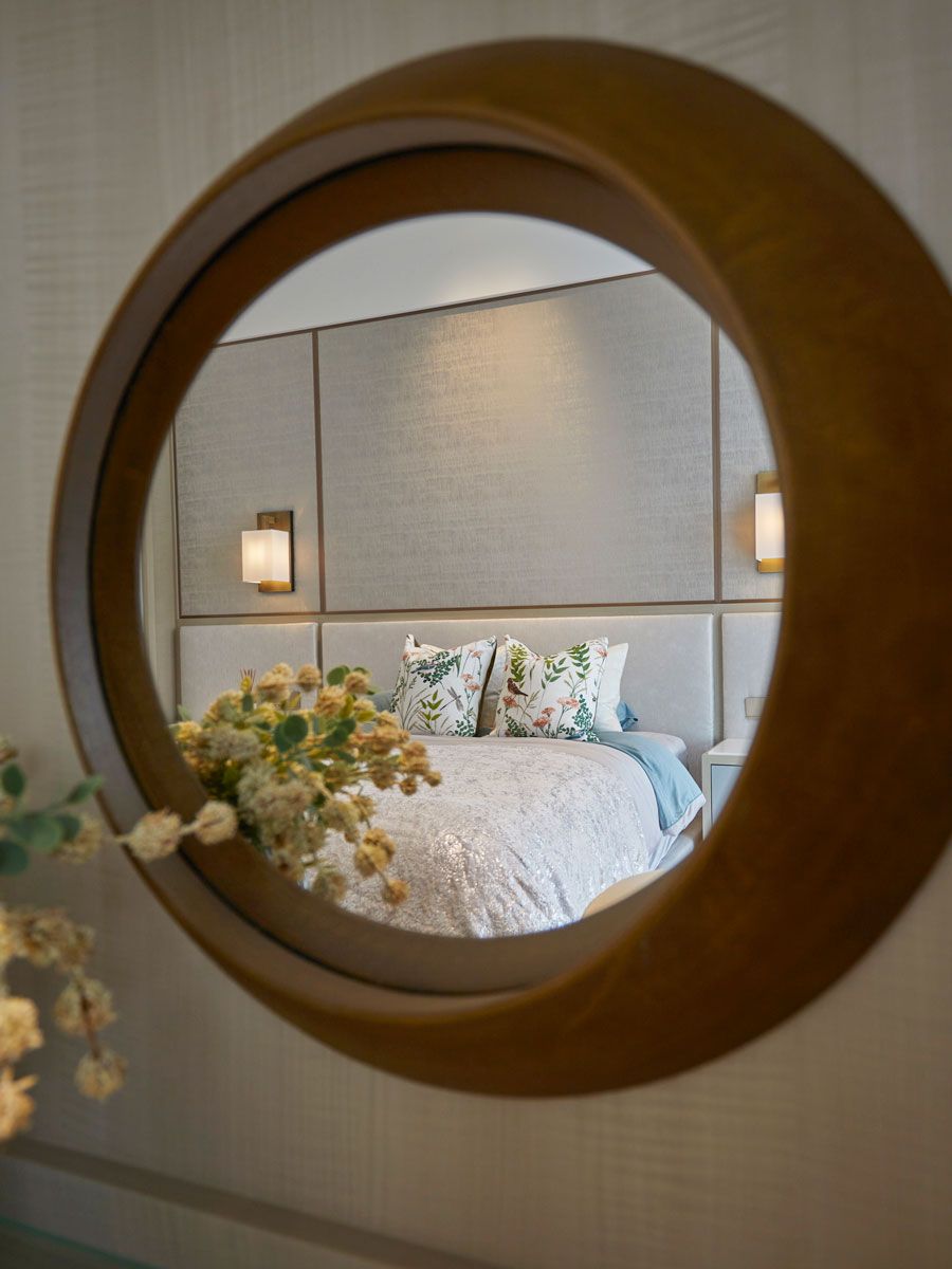 An accent mirror acts as a focal point in the master bedroom