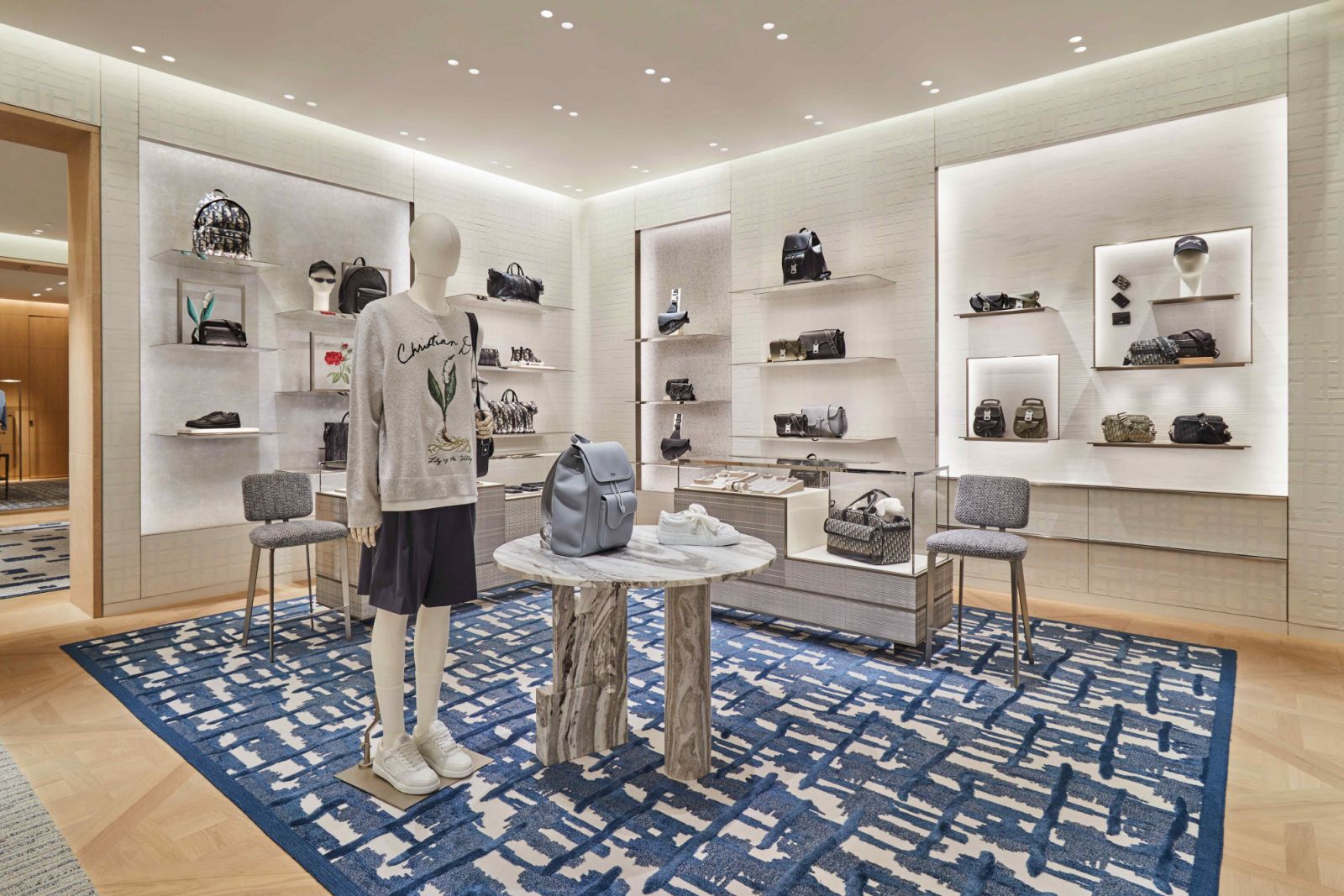 Tasteful furnishings of marble display tables and patterned rugs (Photo: Dior)